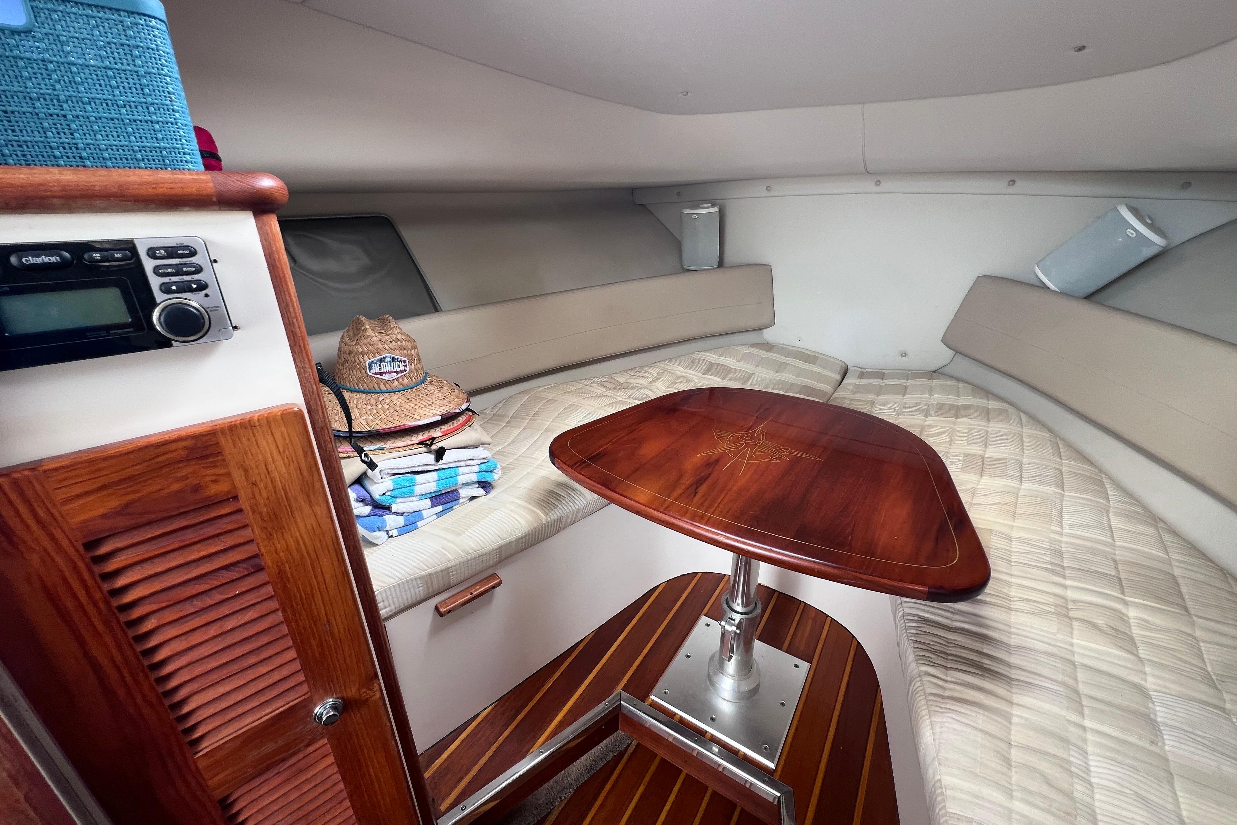 Cozy cabin interior of 2005 Pursuit 3070 Offshore boat with wooden table and seating.