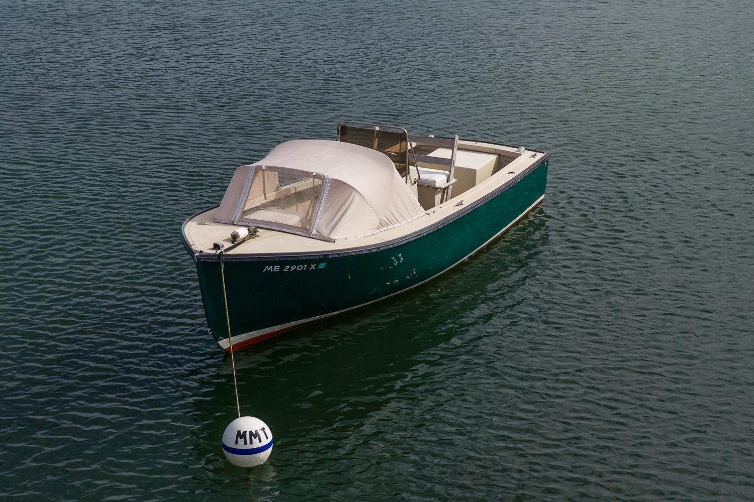 1989 Ellis 24 Open boat moored on calm water with a buoy.