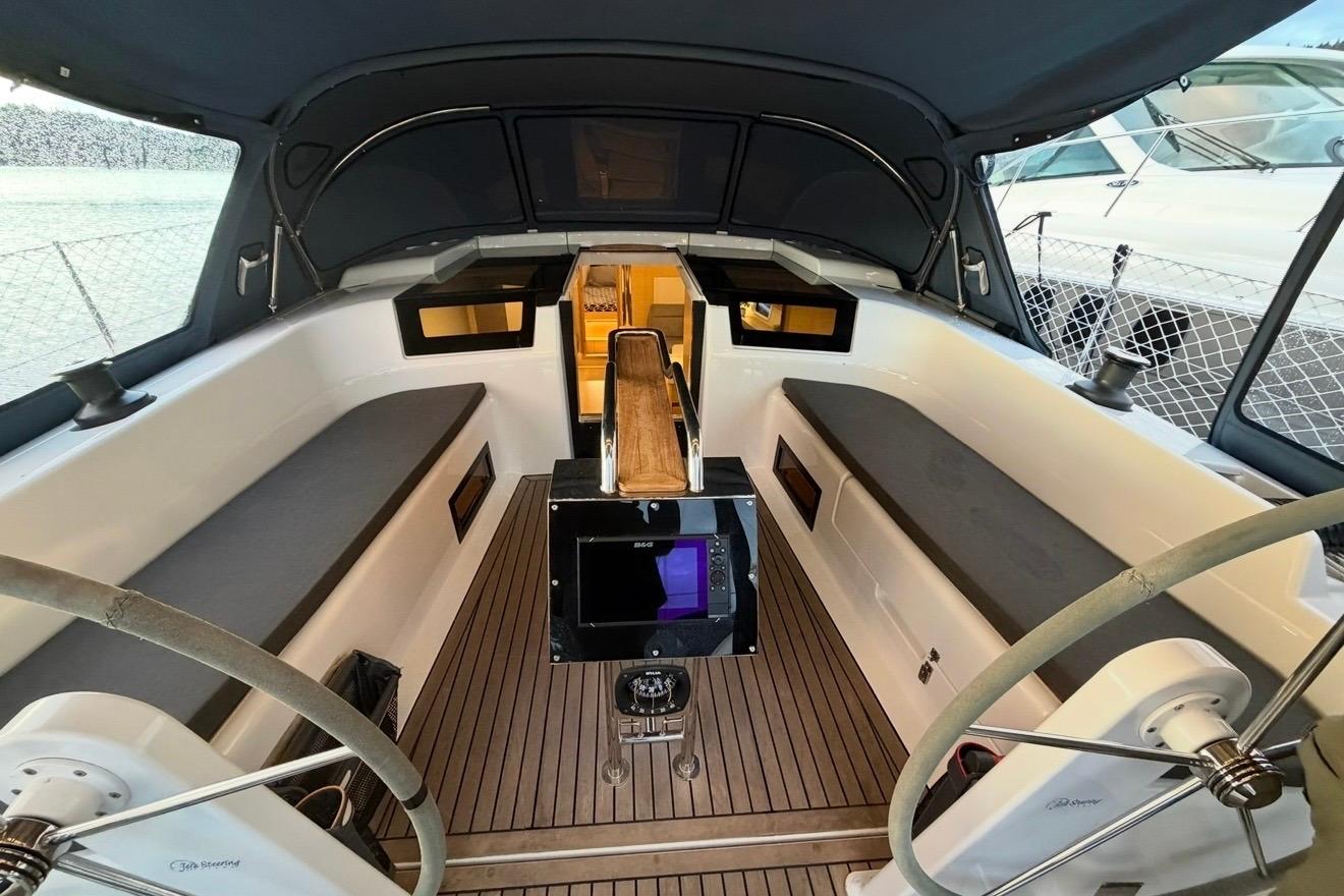 Interior view of 2022 Hanse 418 sailboat cockpit with dual steering wheels and modern design.