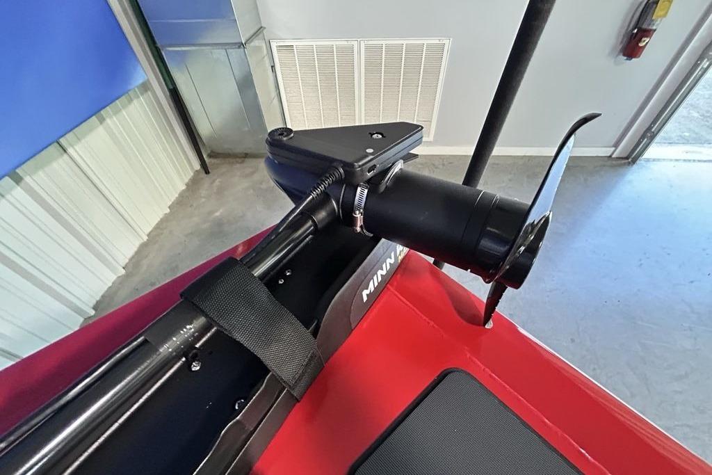 2026 Tracker Pro Team 195 boat with Minn Kota trolling motor in a garage.