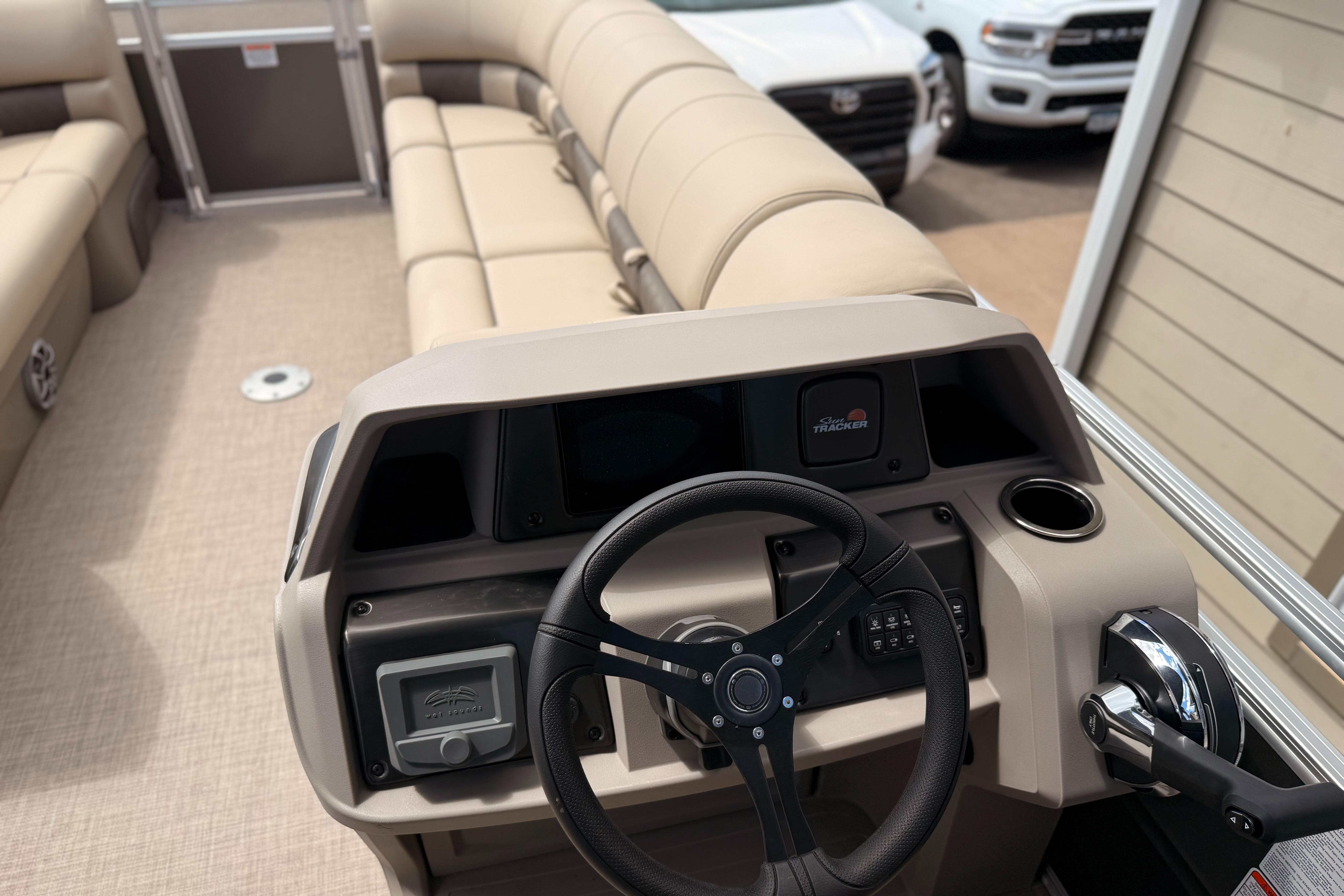 2024 Sun Tracker Party Barge 24 DLX interior with steering wheel and seating.