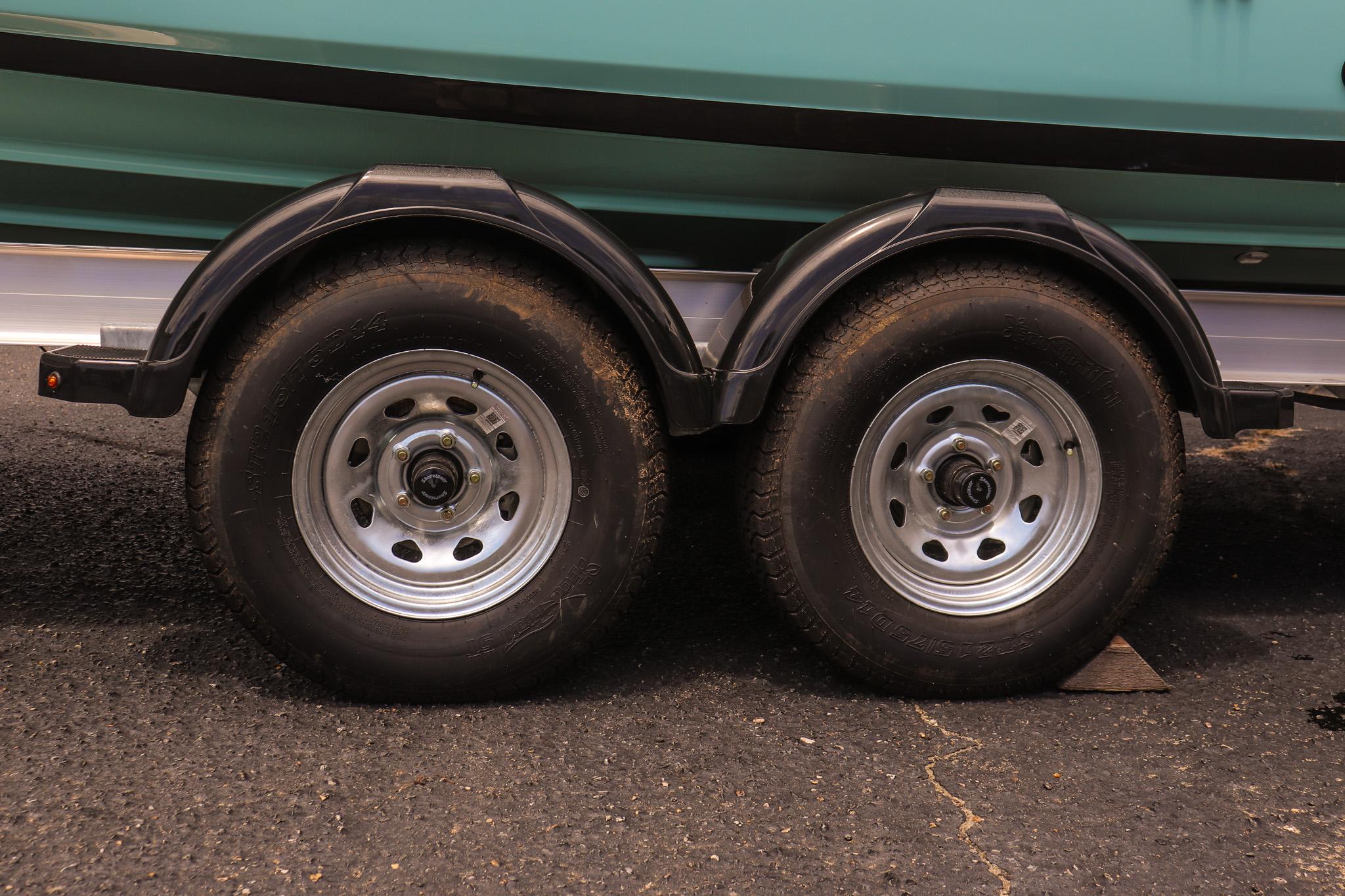 Trailer wheels of 2025 Yamaha Boats 255 FSH Sport E on asphalt surface.