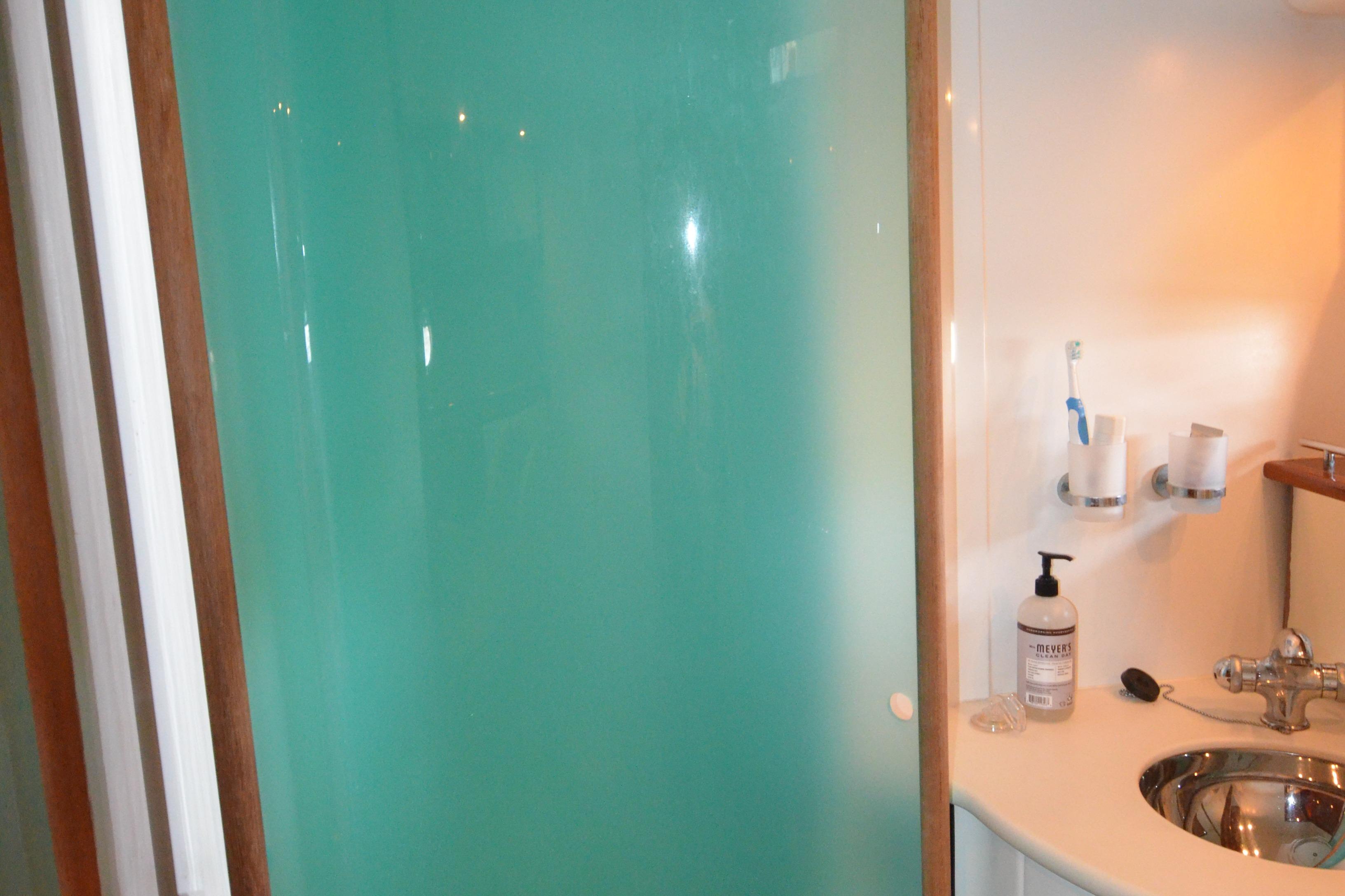 Bathroom interior of 2007 Jeanneau Prestige 46 yacht with frosted glass shower.
