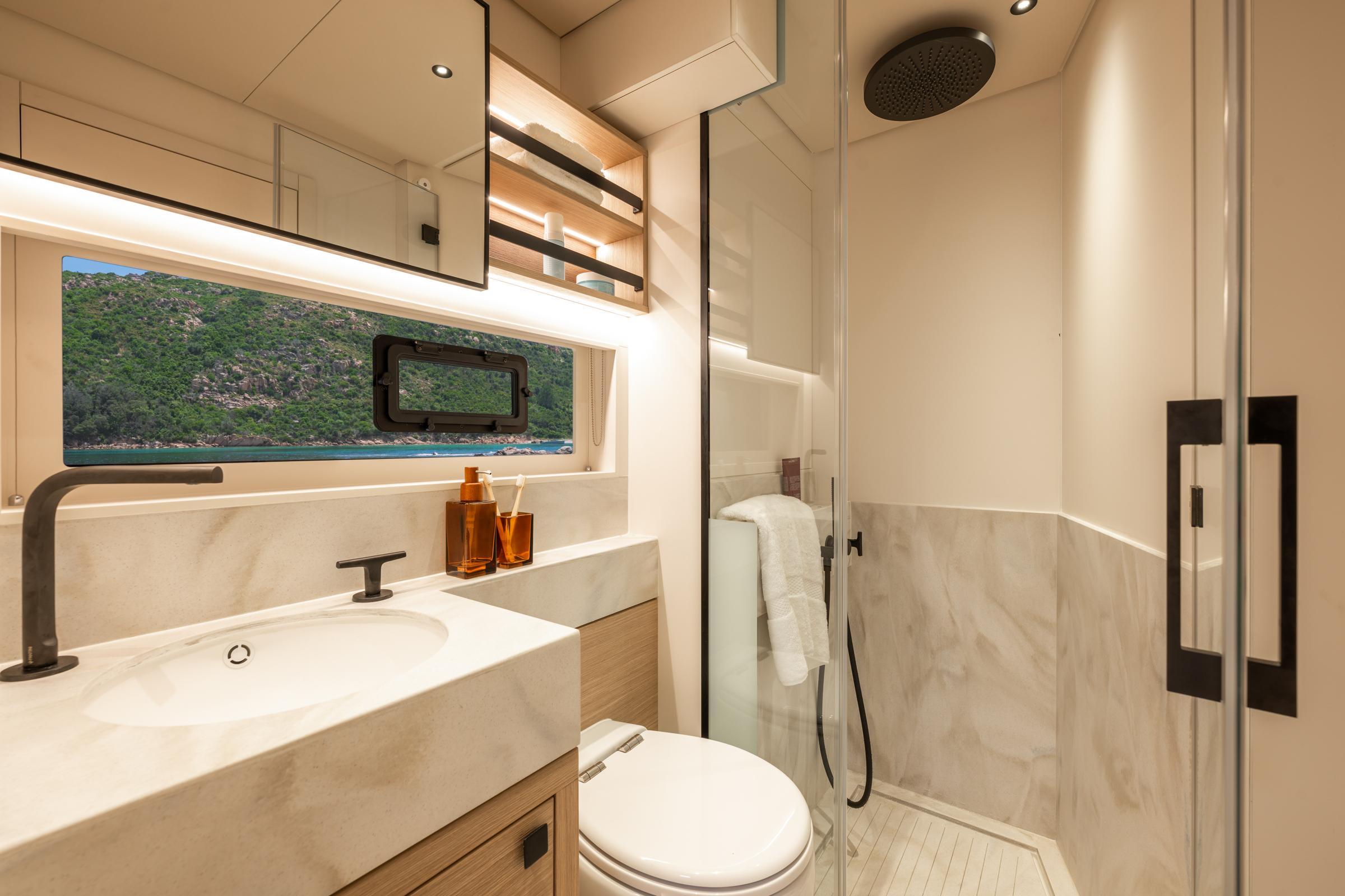 Luxurious bathroom in 2025 Lagoon Eighty 2 yacht with modern fixtures and scenic window view.