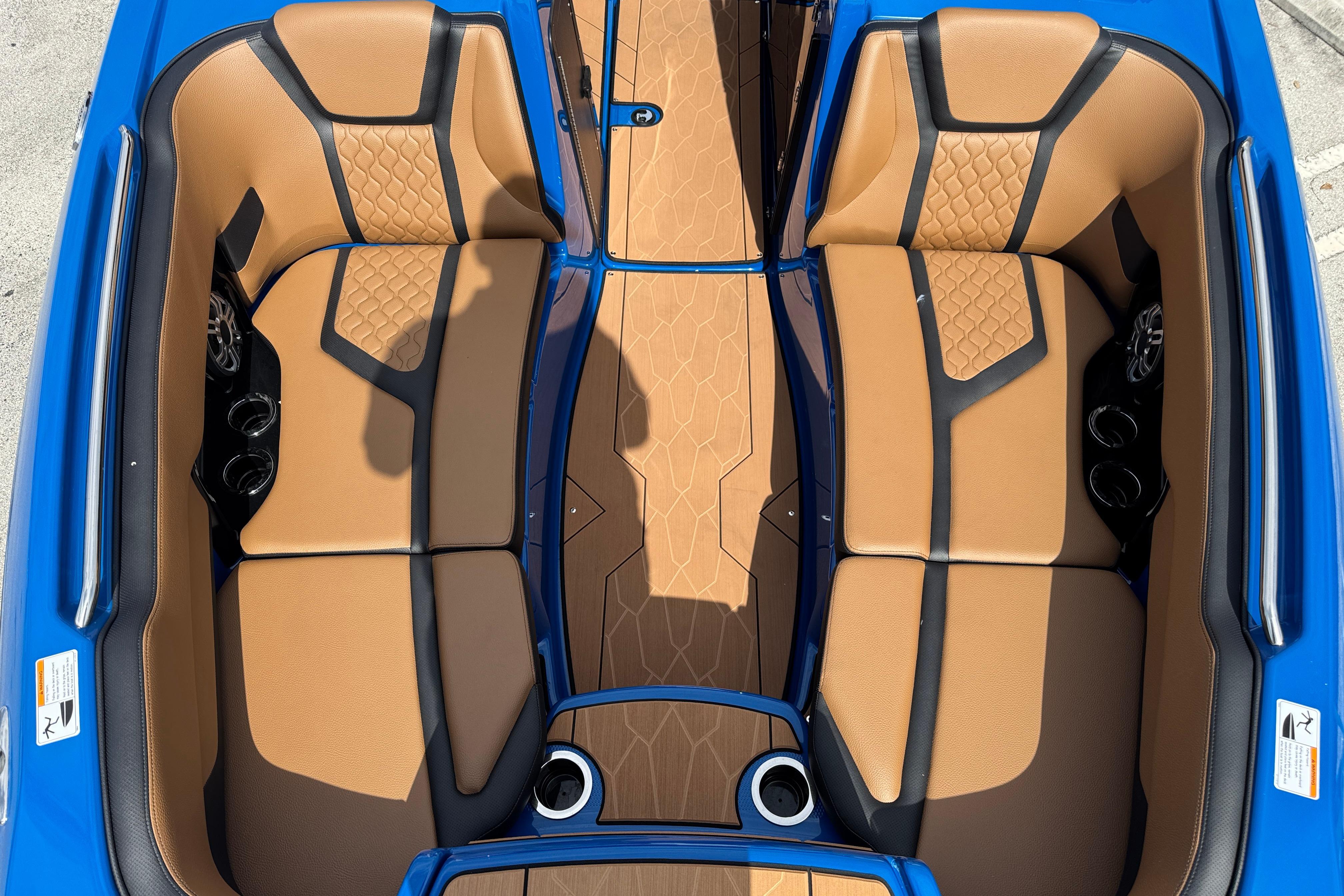 2026 Yamaha Boats 255XD interior with tan and black seating, blue accents, and cup holders.