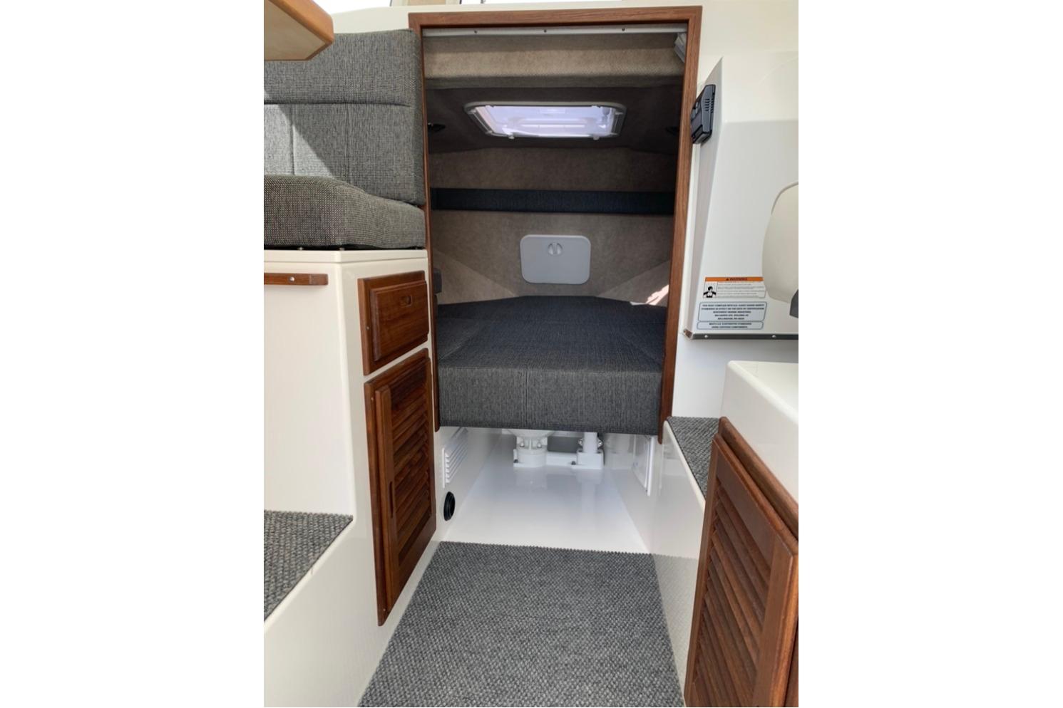 Interior cabin of 2026 Sea Sport Kenai 2600 boat with cozy sleeping area.