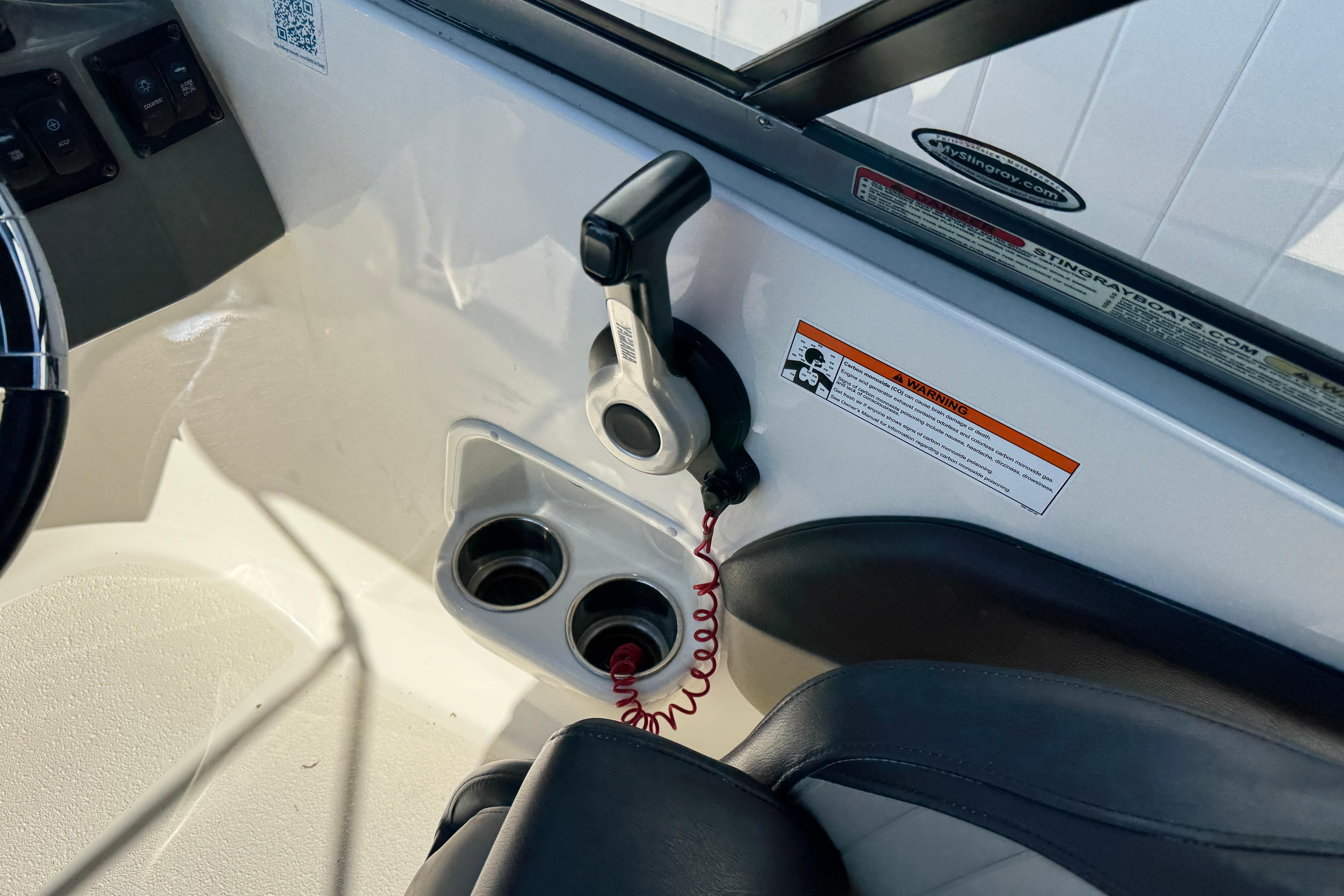 Interior of 2018 Stingray 204 LR boat showing throttle control and cup holders.