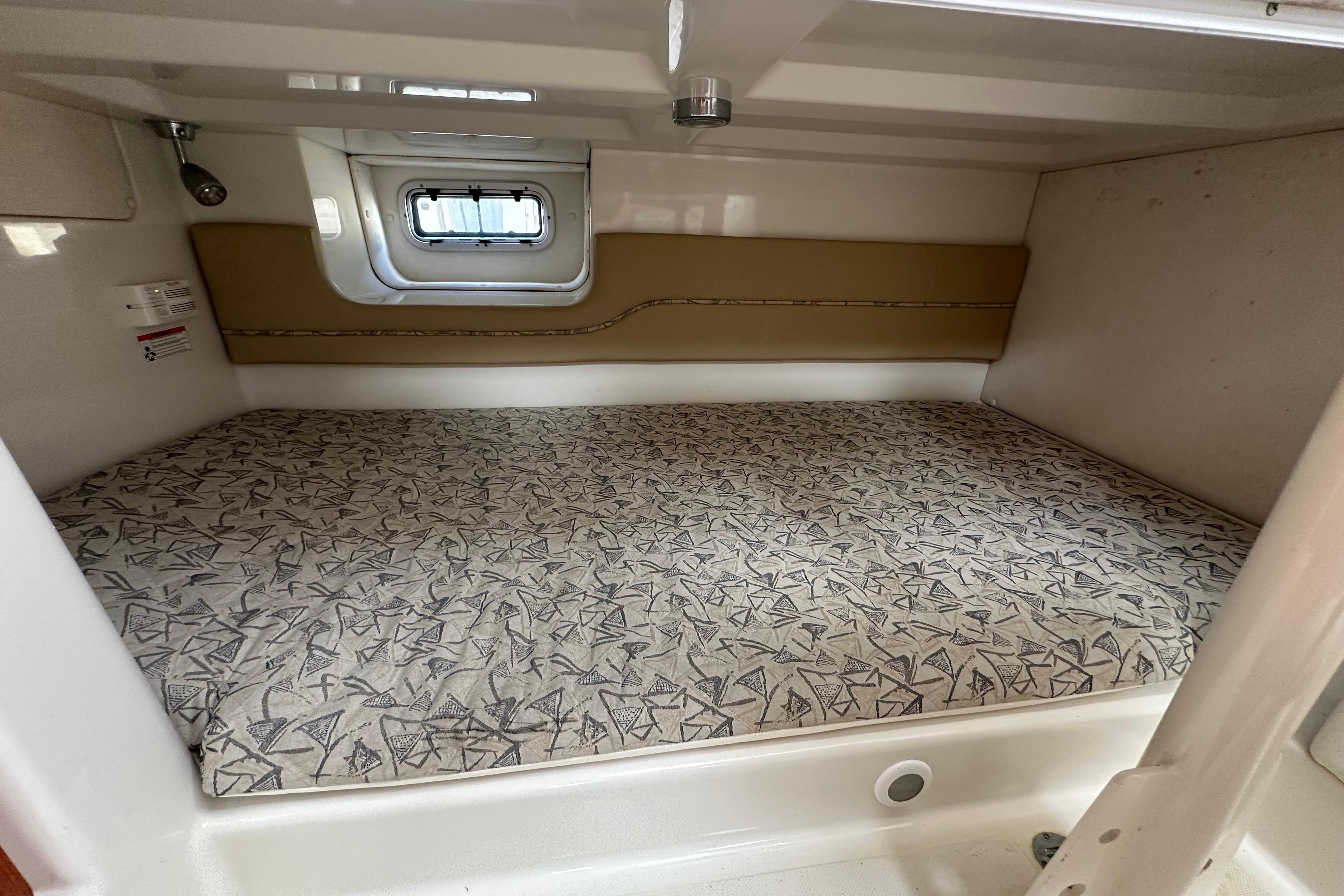 2006 Pro-Line 32 Express cabin interior with patterned bed and small window.