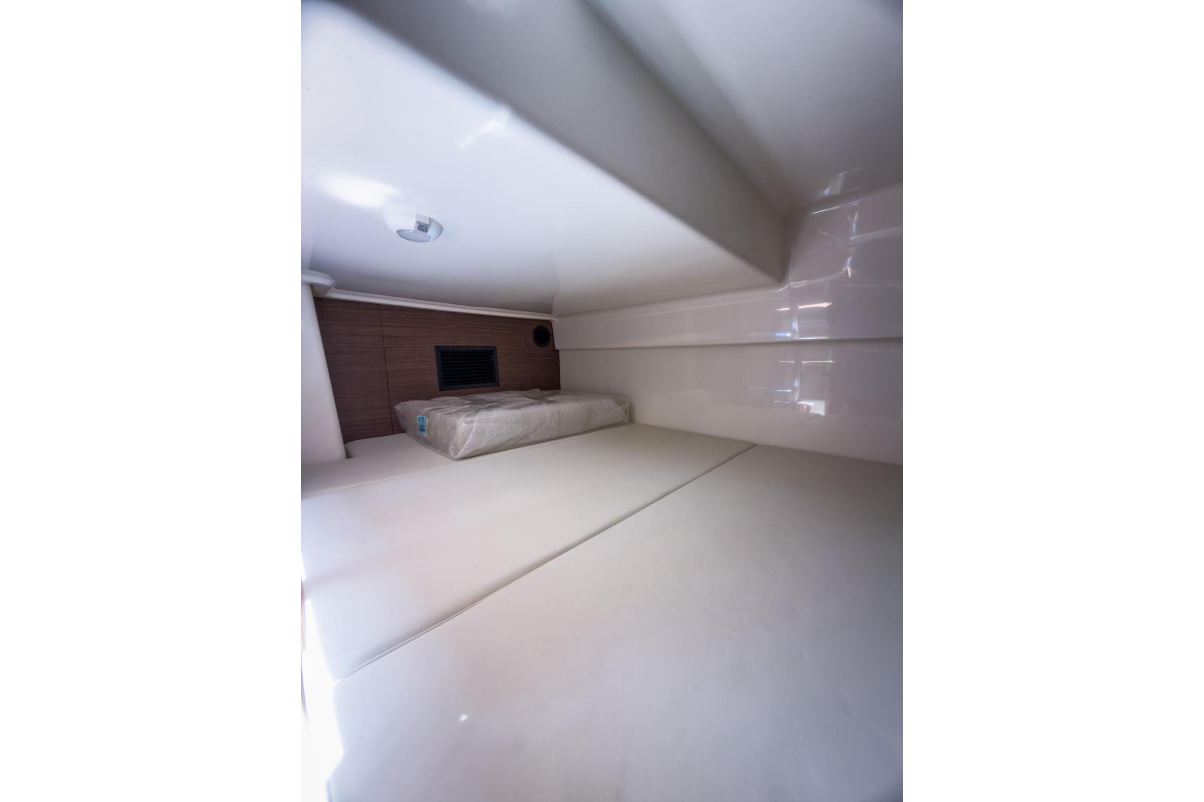 Interior cabin of 2024 Boston Whaler 325 Conquest, featuring a cozy sleeping area.