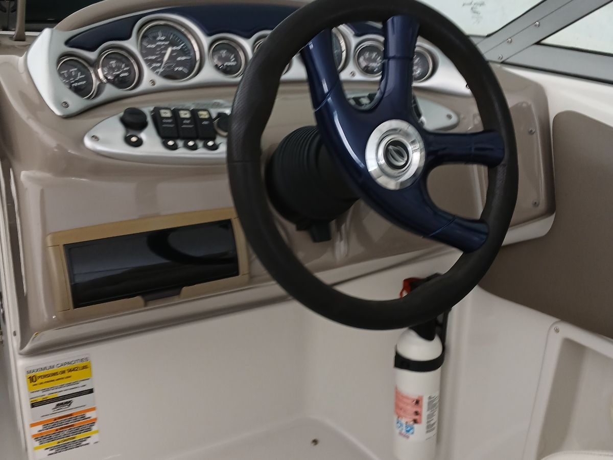 Dashboard of a 2005 Crownline 220 EX boat with steering wheel and gauges.