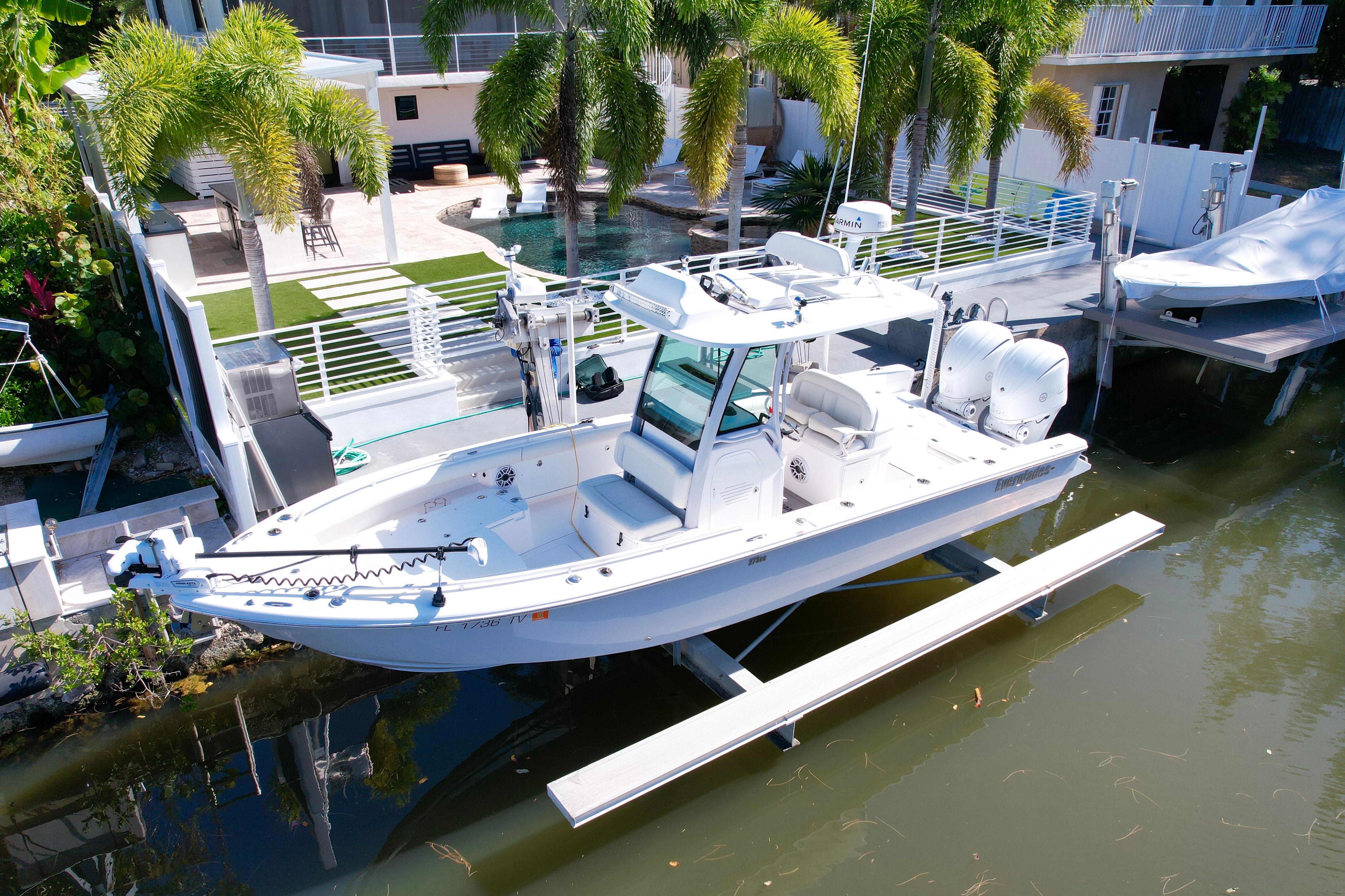 2021 Everglades 273 Center Console boat docked near a luxurious waterfront property.