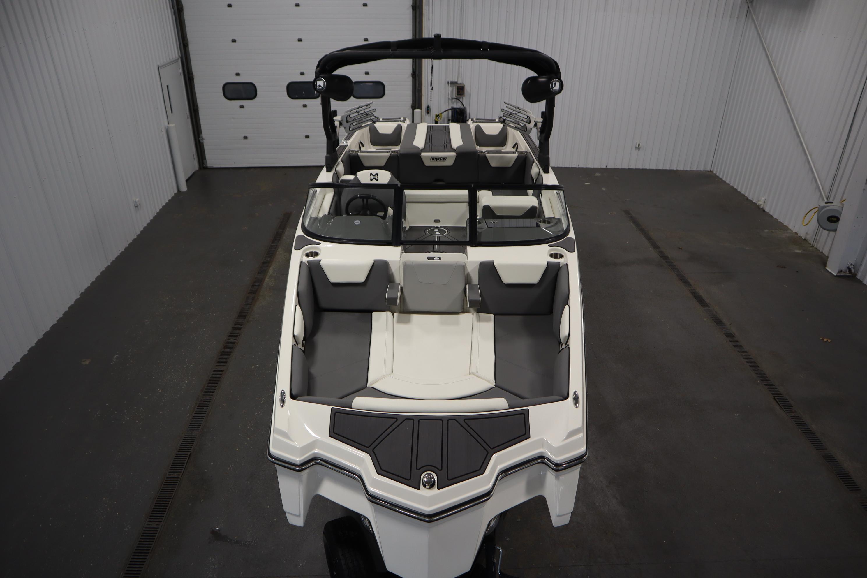 2023 Heyday WT Surf boat in a garage, showcasing sleek design and spacious seating.