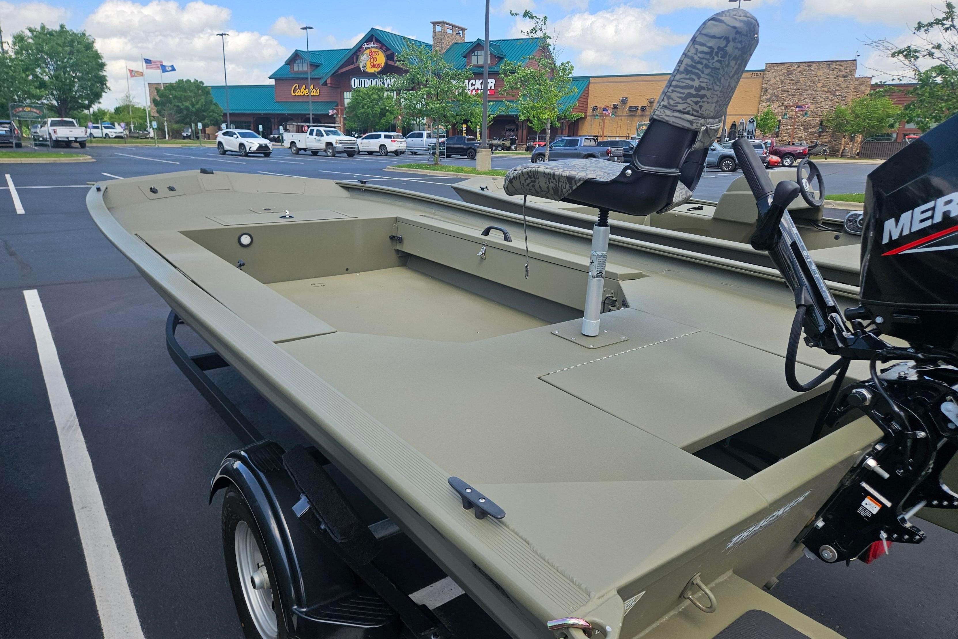 2026 Tracker Grizzly 1654 T Sportsman boat in parking lot, featuring camo seat and Mercury motor.