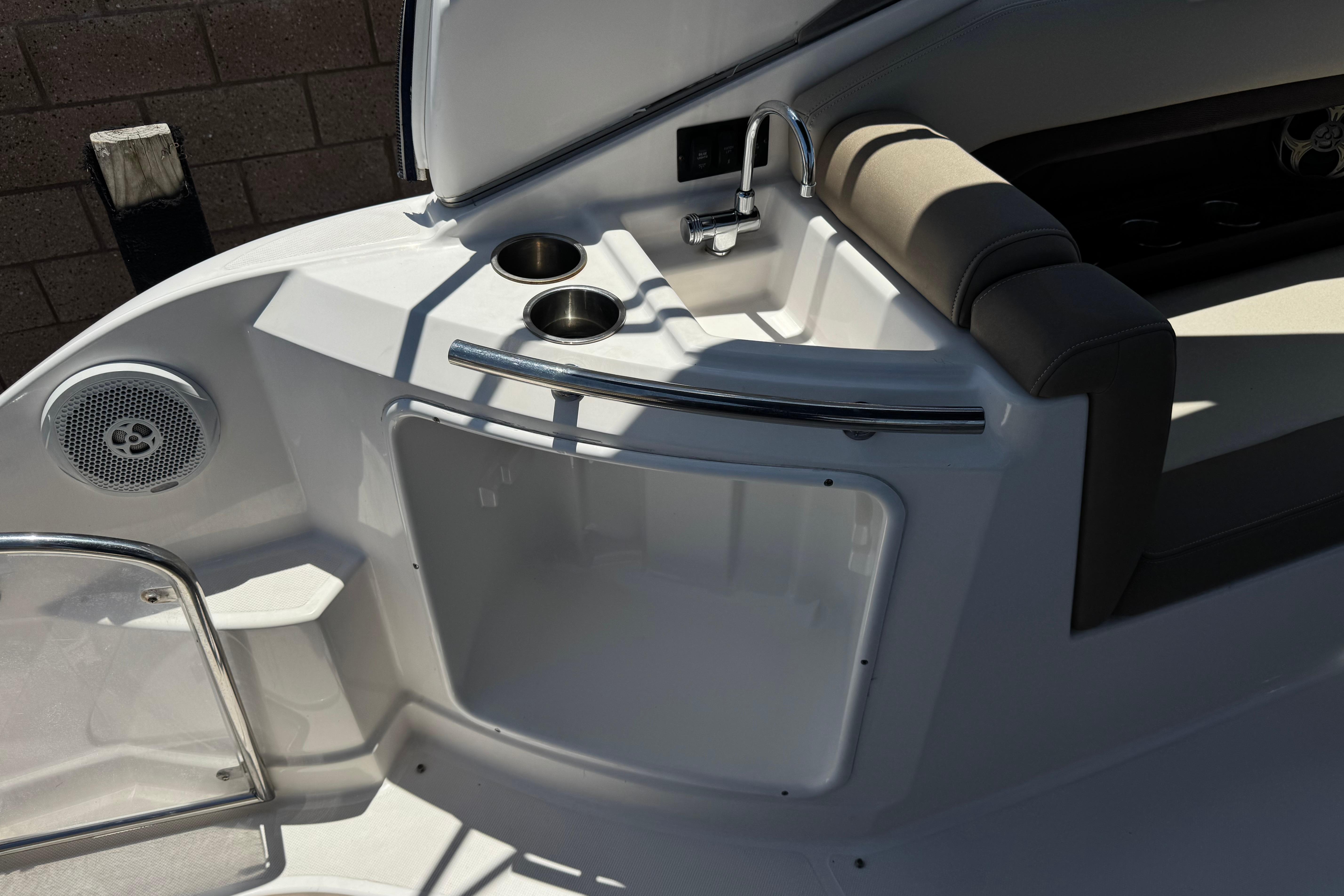 Interior of 2013 Regal 28 Express boat featuring sink, cup holders, and seating area.