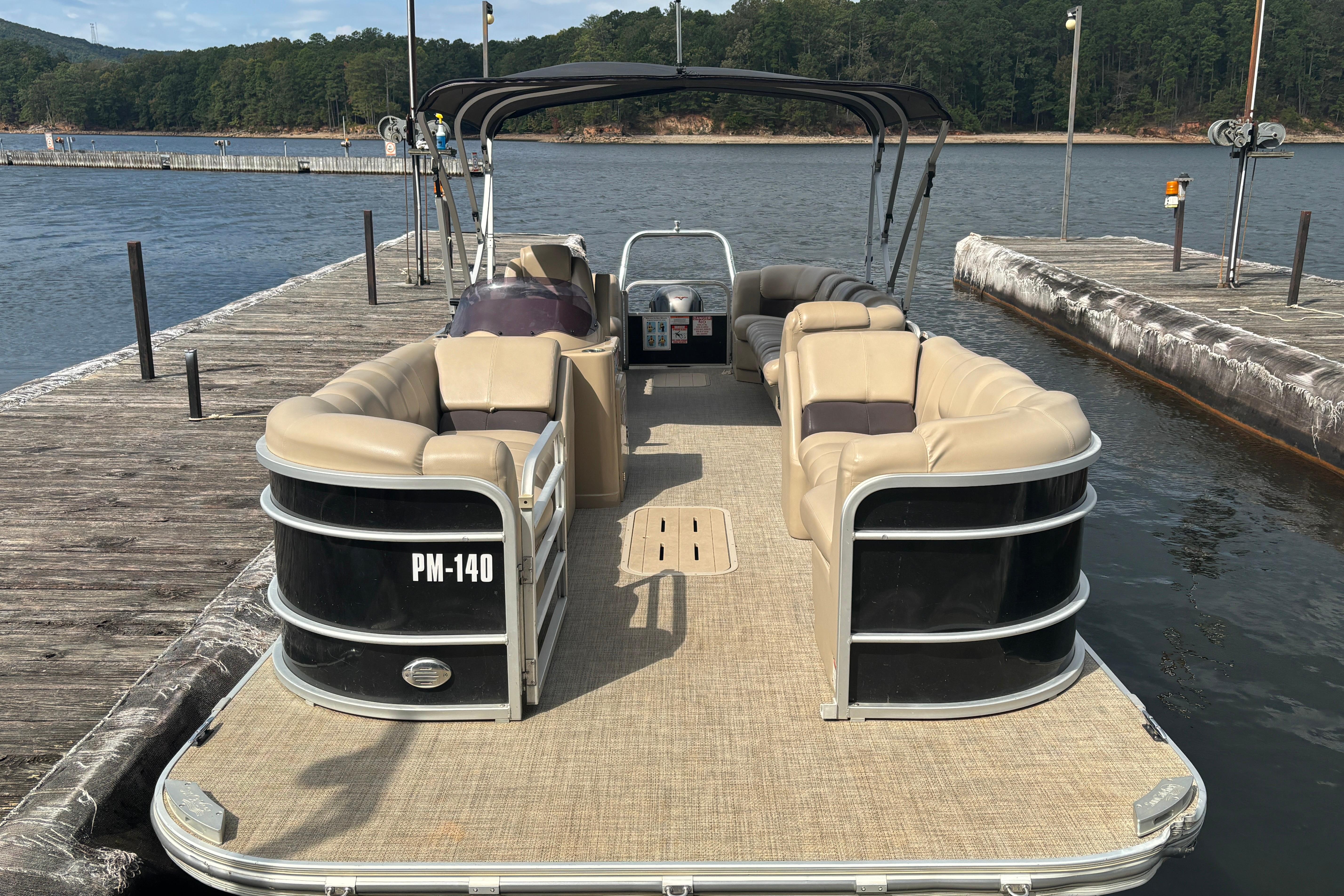 2021 SunCatcher Fusion 325RCX pontoon boat docked on a serene lake.
