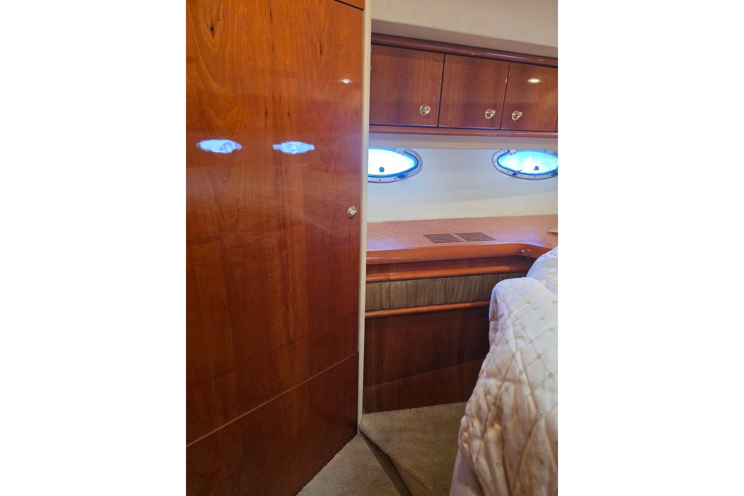 Interior of 2000 Neptunus 56 Express yacht with wood cabinetry and porthole windows.