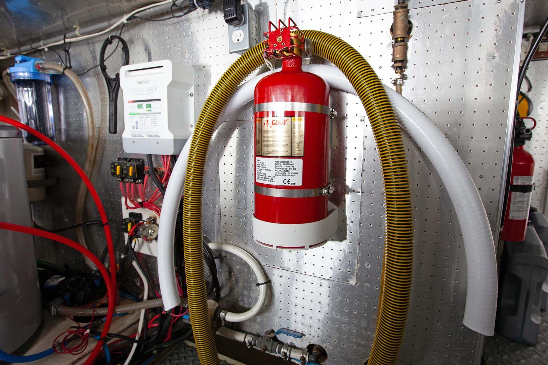Engine room of 1997 McKinna 48' Pilot House with fire extinguisher and equipment.