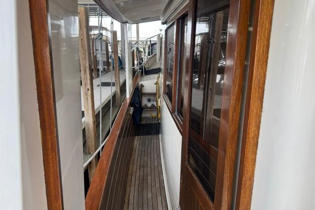 Side deck view of a 1986 Kadey-Krogen 42 yacht with wooden accents and docked surroundings.