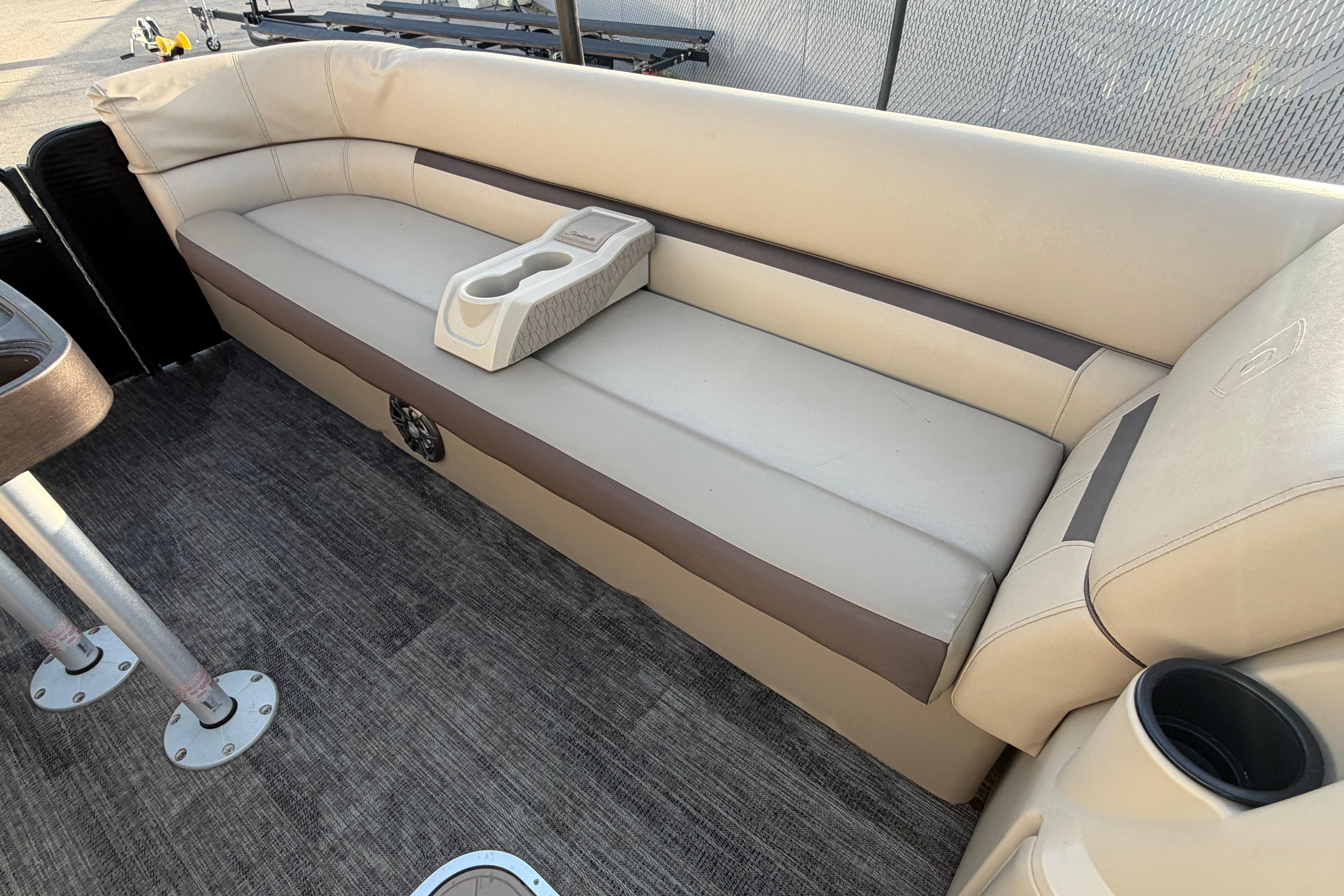 2023 Godfrey Sweetwater 2286 C boat interior with beige seating and cup holders.
