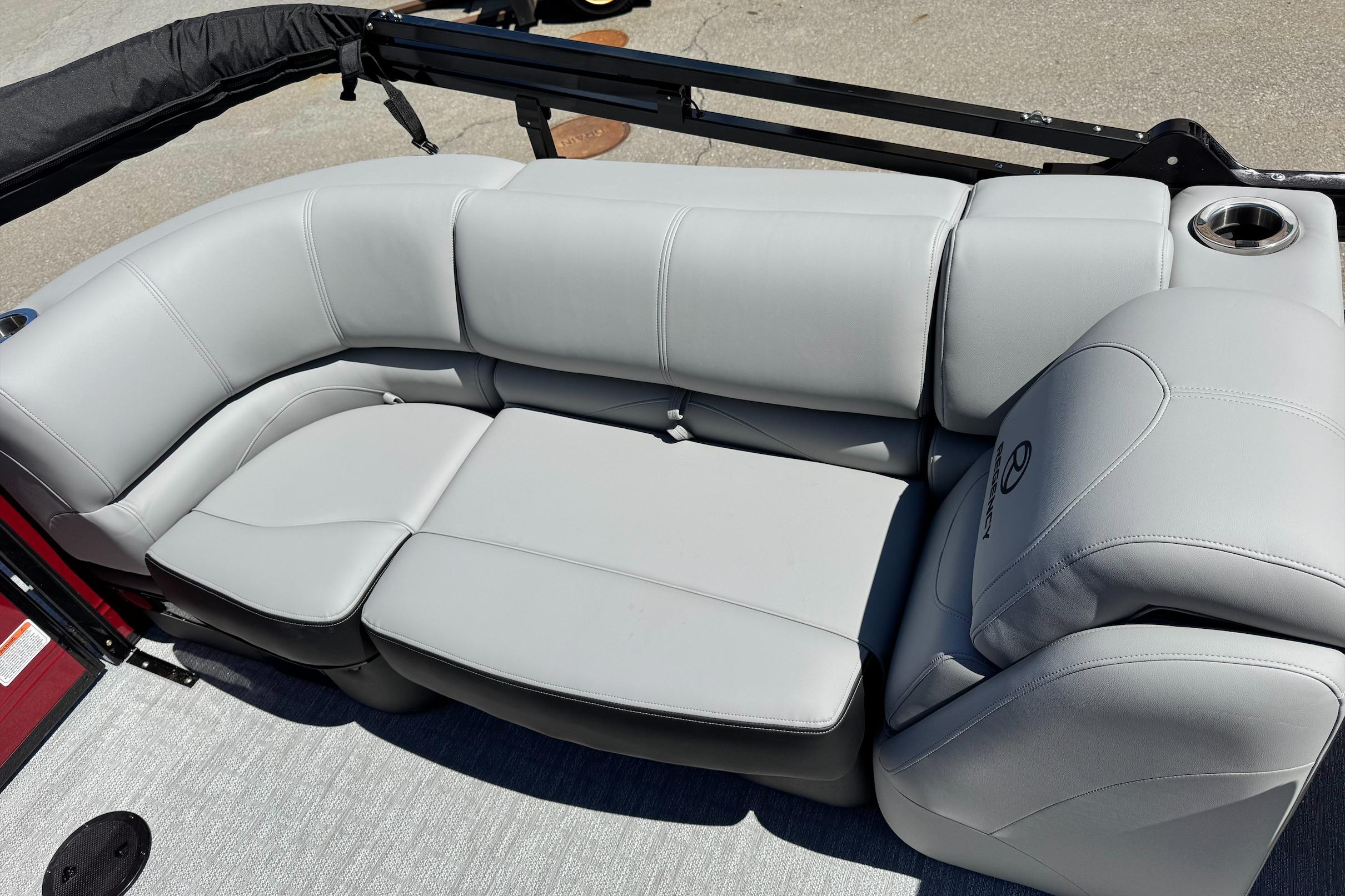 Luxurious seating on 2026 Regency 230 DL boat, featuring sleek gray upholstery and cup holder.