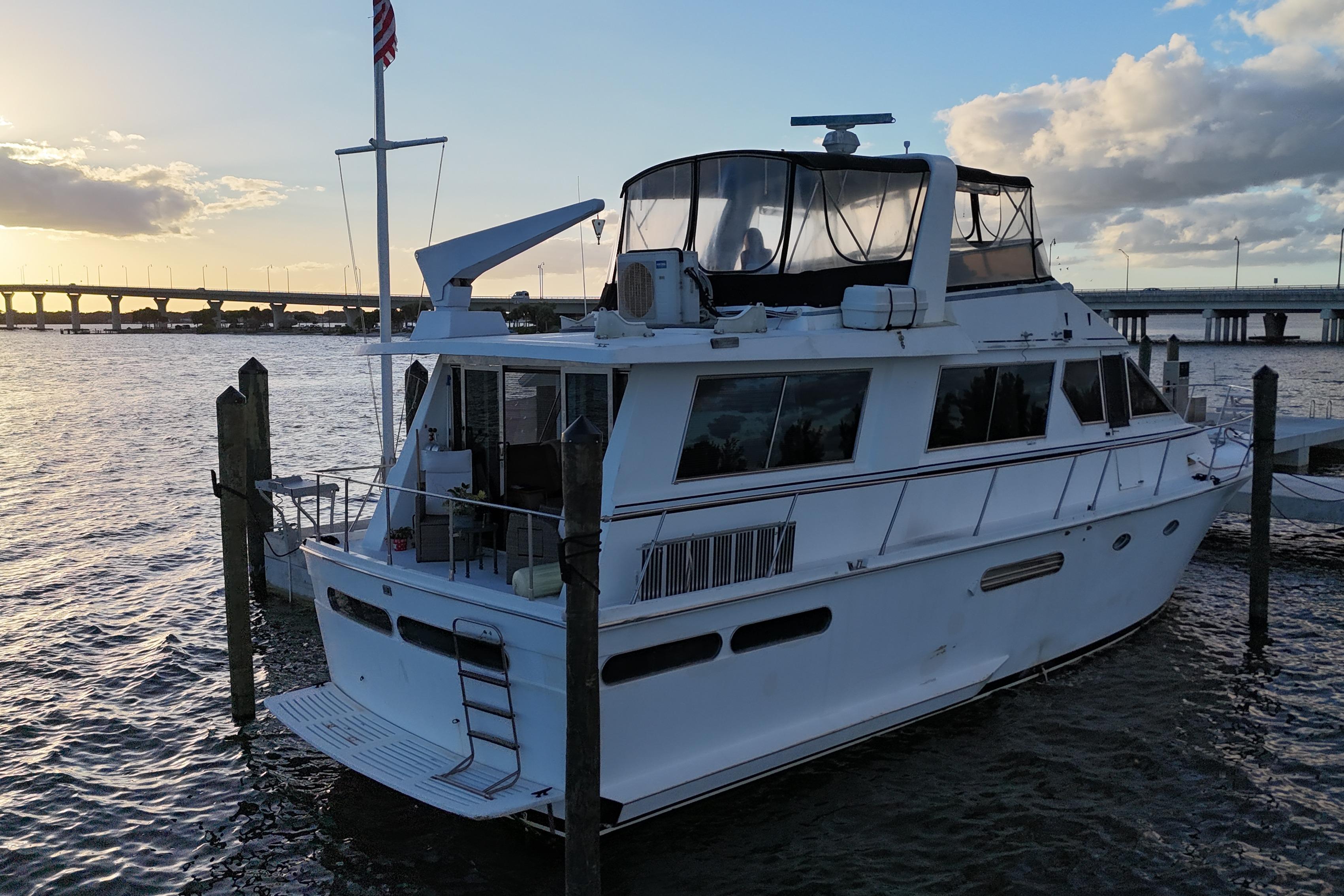 1987 Viking Gulfstar yacht docked at sunset, with bridge and water in the background.
