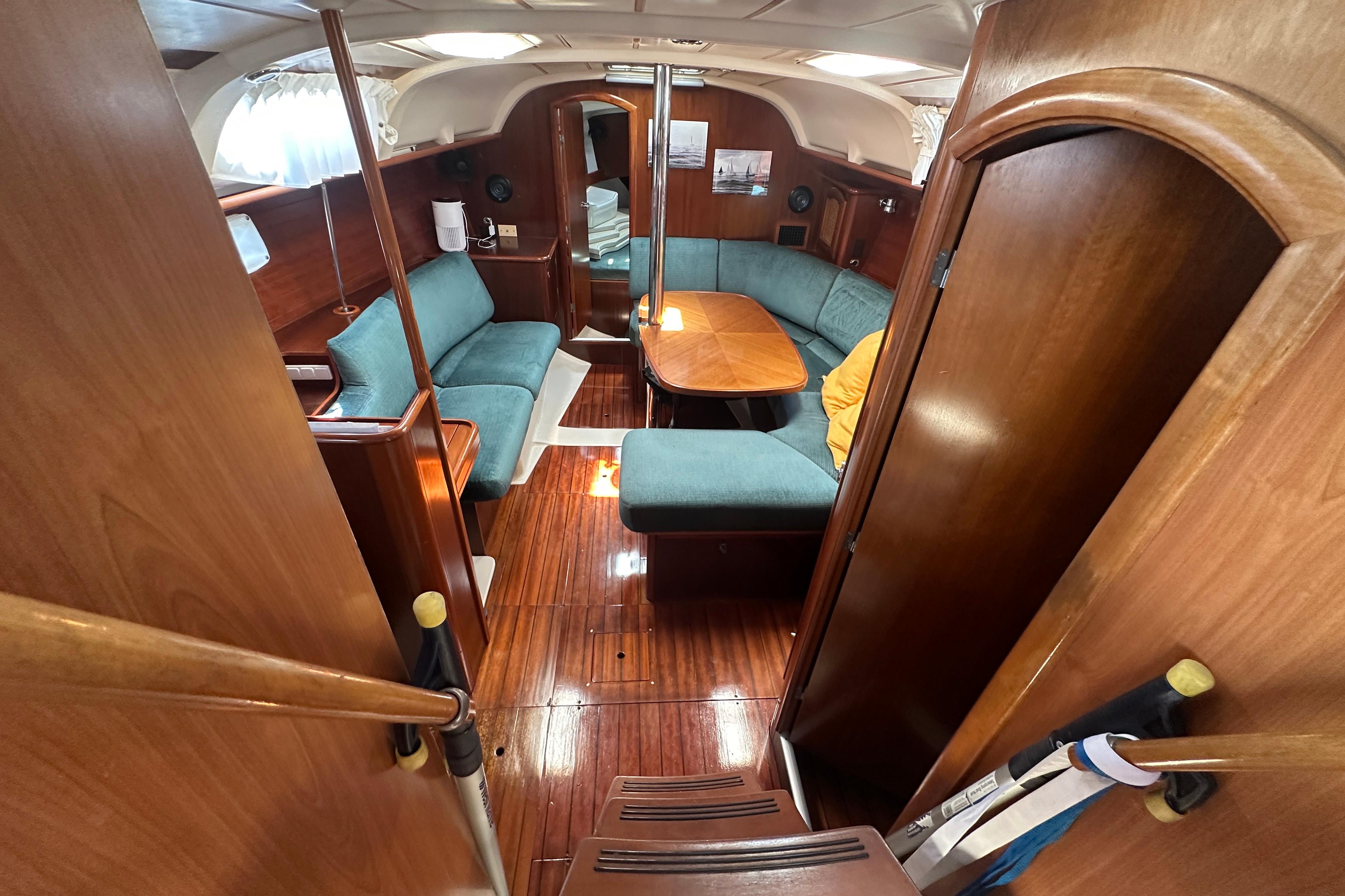 Interior of 1999 Beneteau Oceanis 352 sailboat with wooden finish and blue seating.