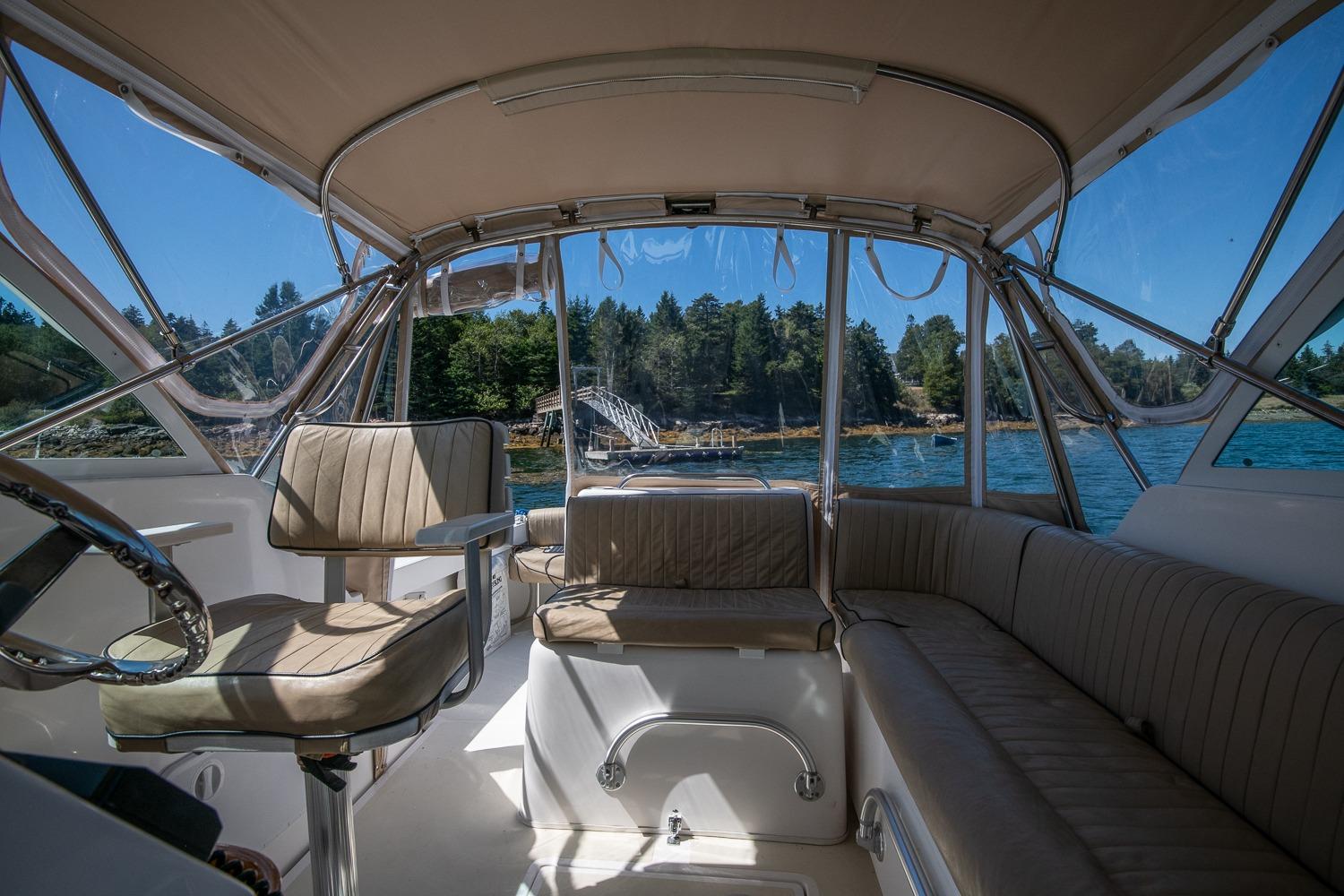 2005 Hunt Yachts Surfhunter 29 interior with seating, steering, and scenic water view.