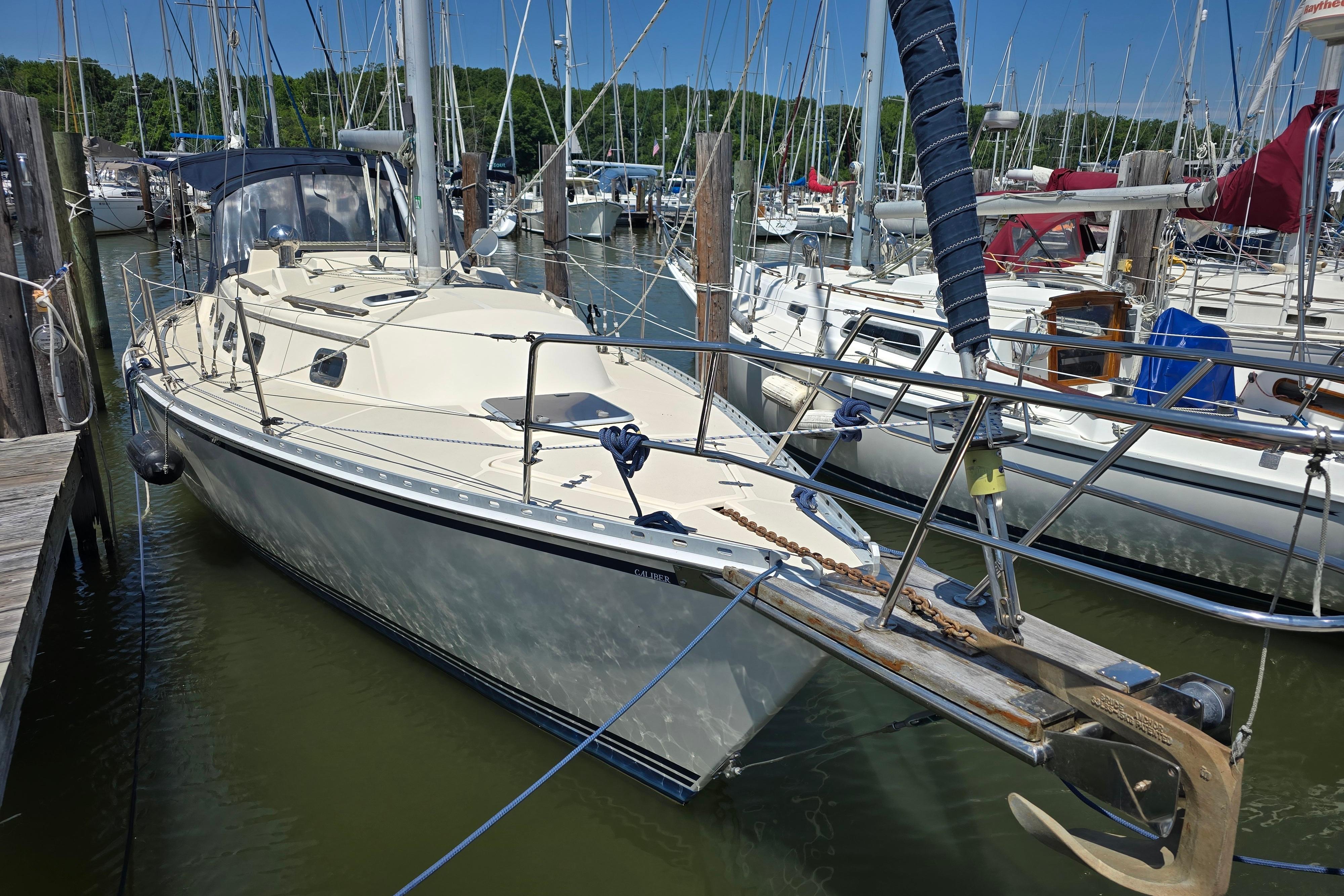 Sailboat docked in marina, 1993 Caliber 35 model, surrounded by other boats.