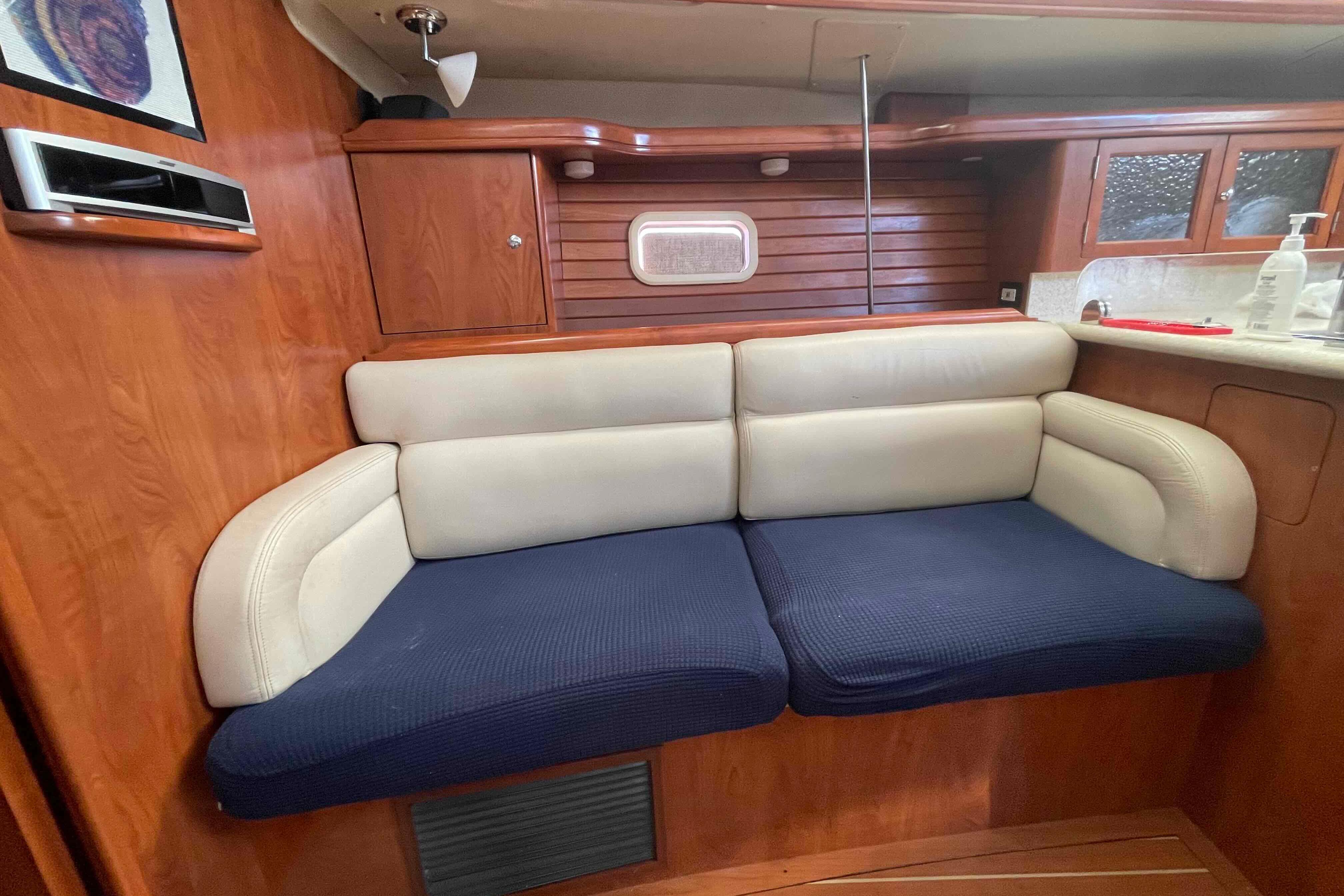 Interior of 2010 Hunter 45 Center Cockpit yacht with cozy seating and wooden cabinetry.