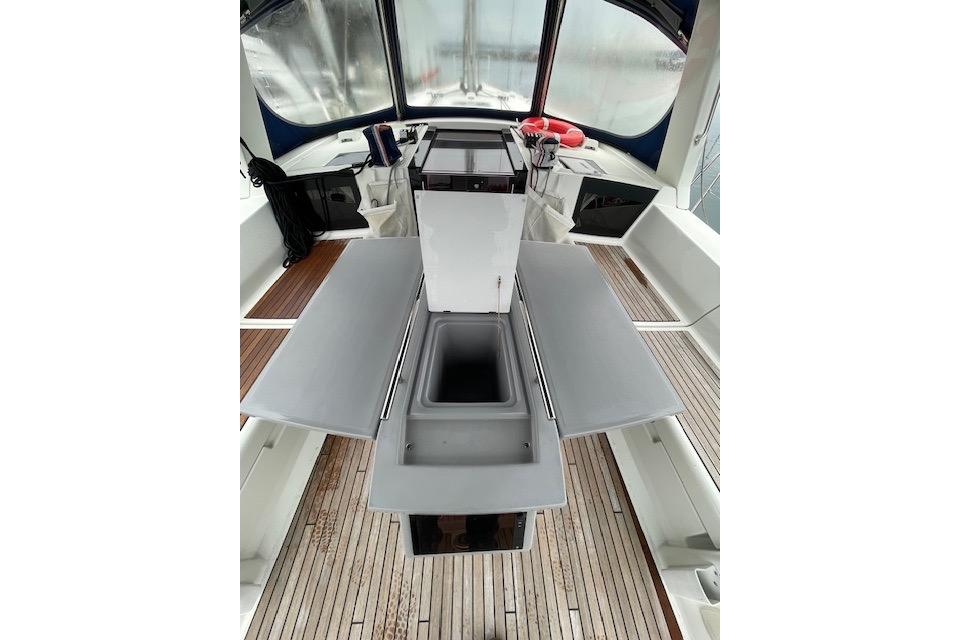 2018 Beneteau Oceanis 45 yacht cockpit with foldable table and sink, featuring teak flooring.