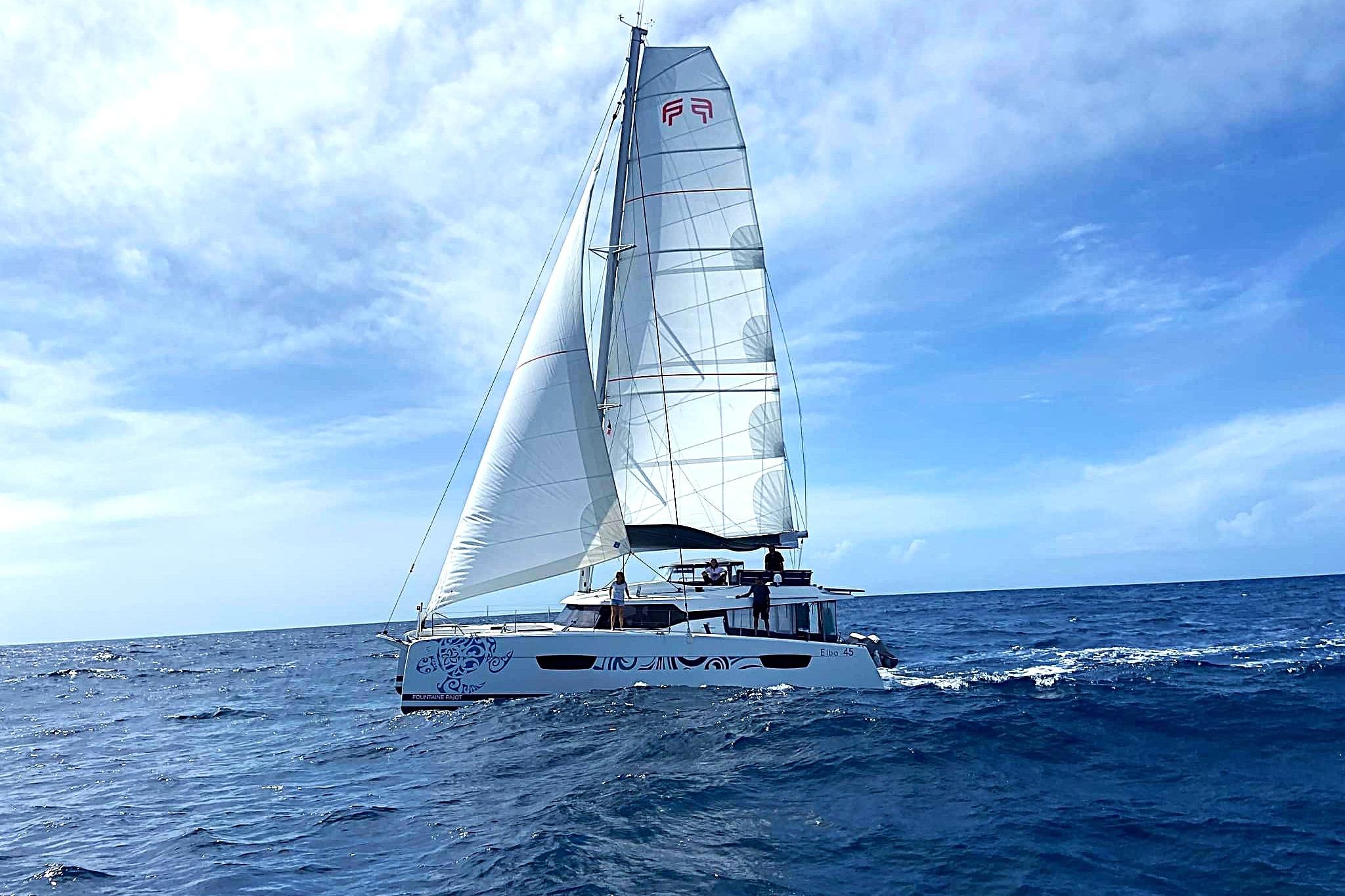 2021 Fountaine Pajot Catamaran Elba 45 sailing on open ocean under clear skies.
