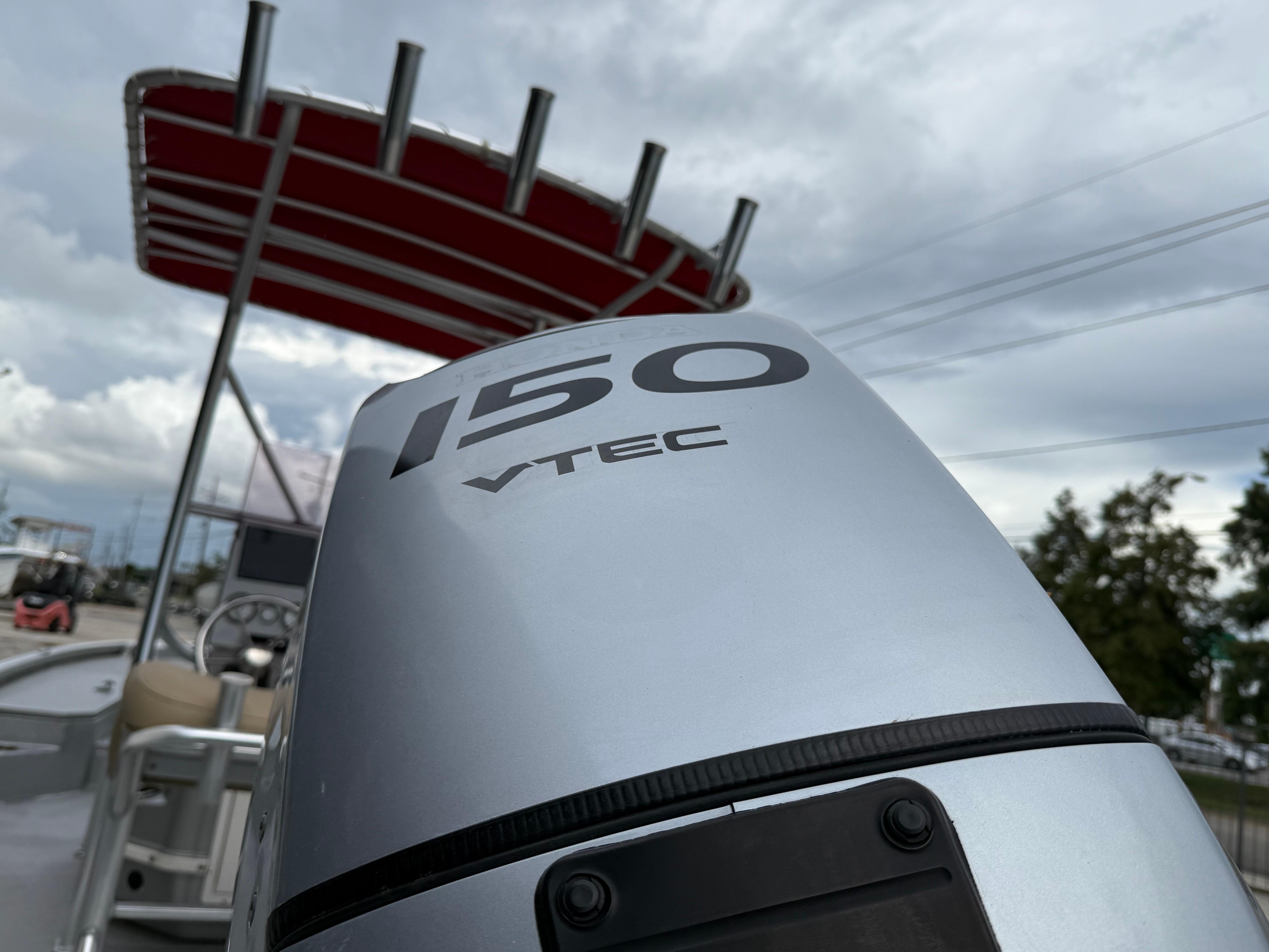 Outboard motor on 2020 Avid 23 FS Platinum boat with red canopy.