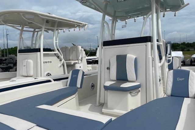 2025 Ranger 2360 Bay boat with blue and white seating, docked outdoors.
