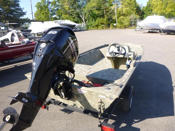 2024 Tracker Grizzly 1648 SC boat with Mercury outboard motor in a parking lot.