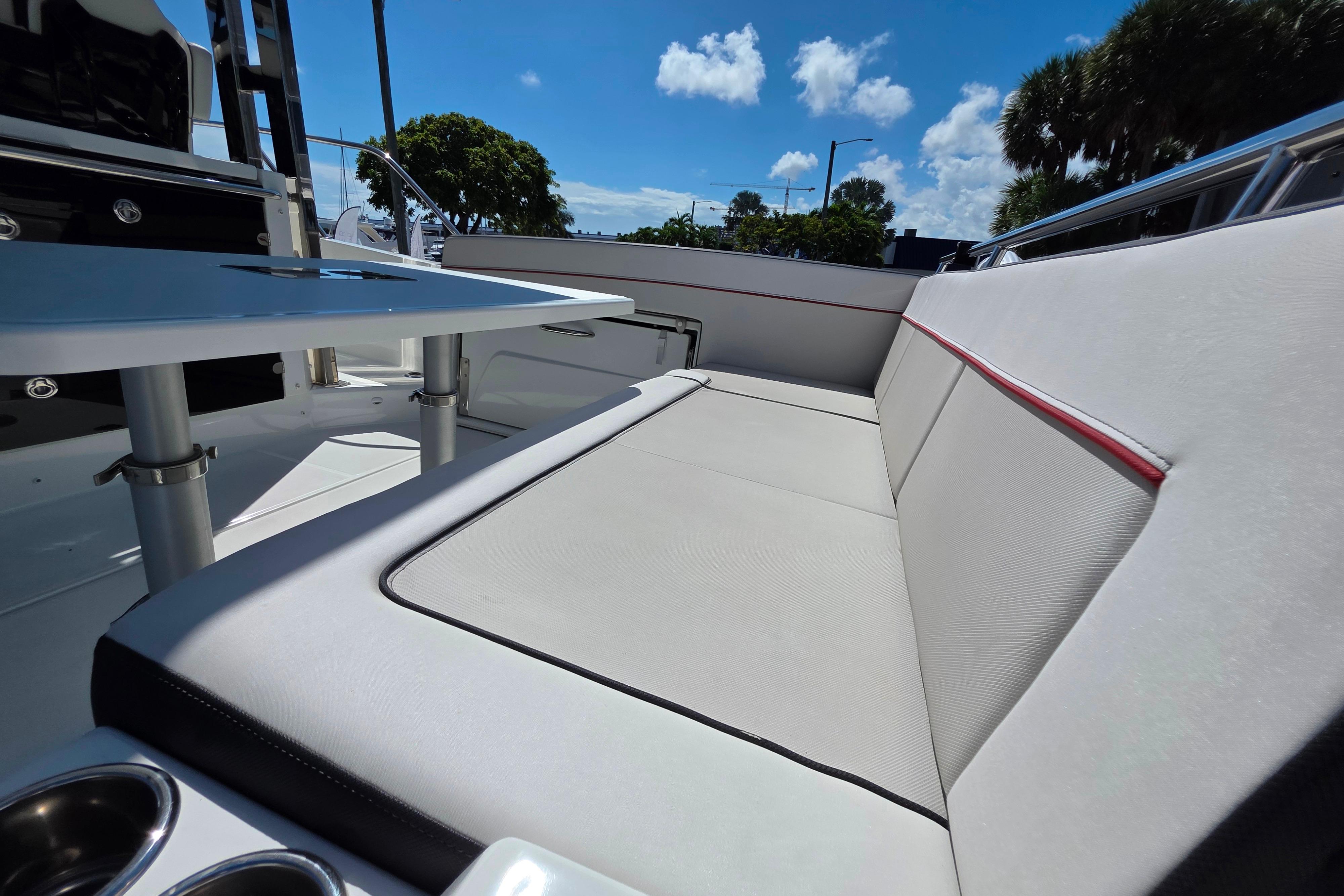 2021 Jeanneau Leader 10.5 WA boat interior with sleek seating and table under blue sky.