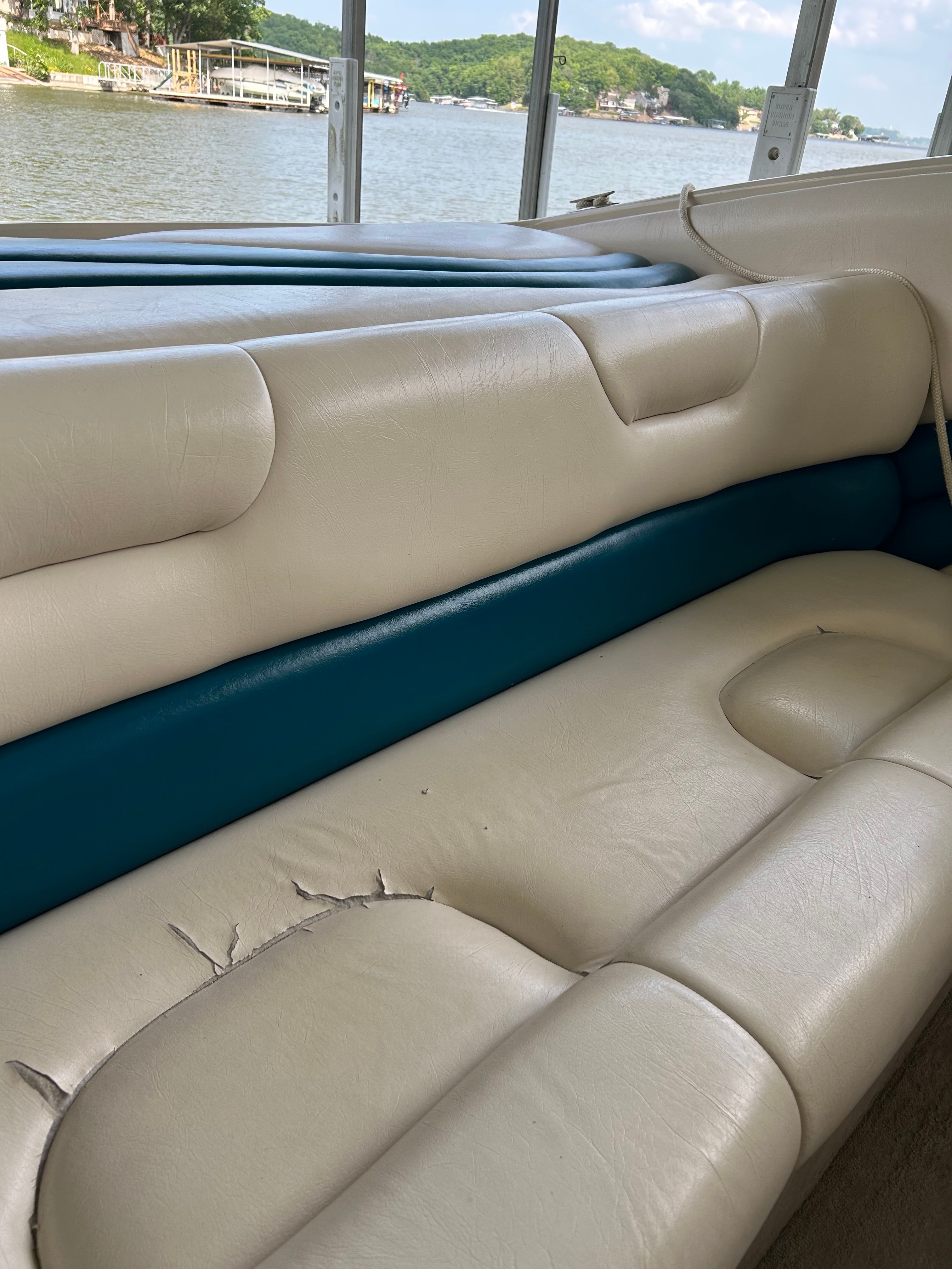 Interior of a 1995 Crownline 266 BR boat with worn seating.