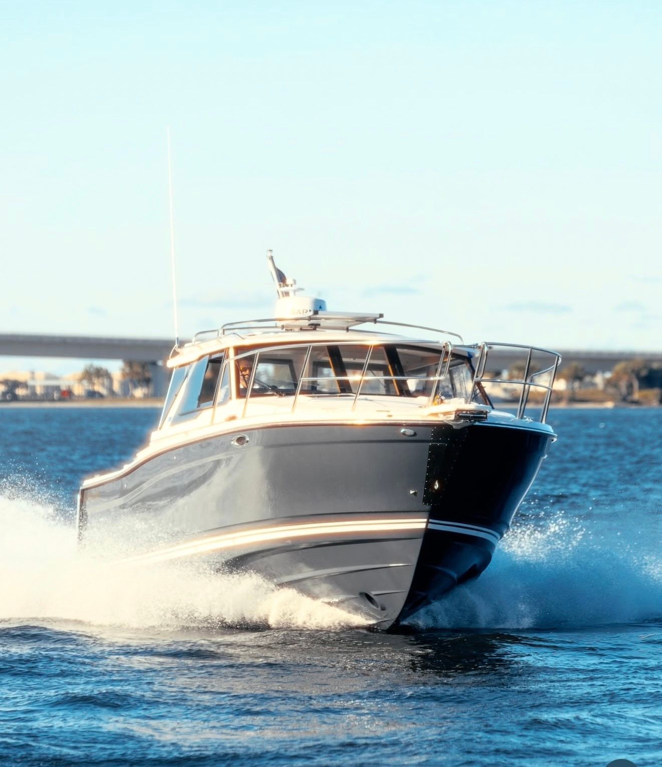 2023 Cutwater C-228 on the water, sleek and powerful, with water splashing around the bow.