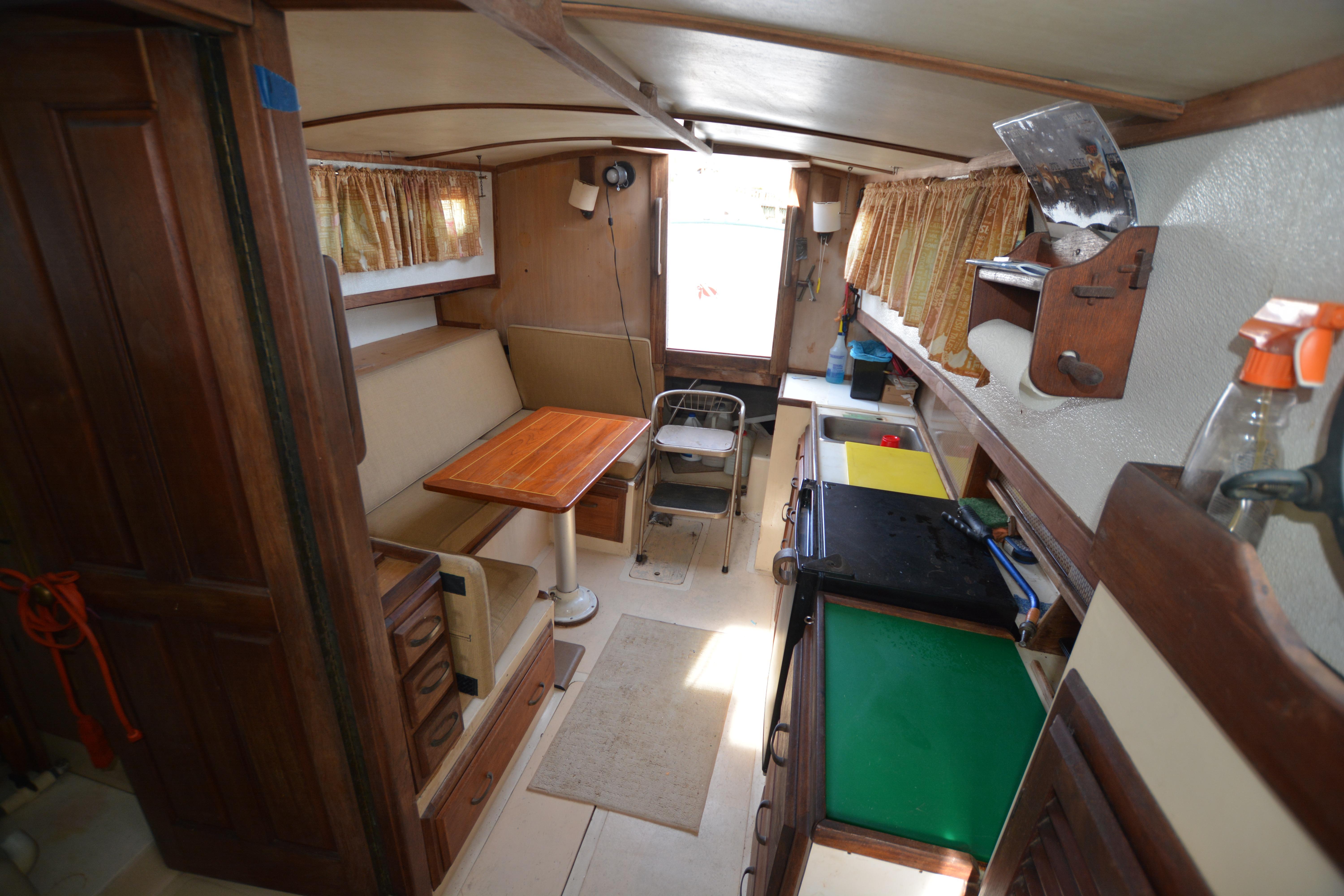 1974 Fales Navigator boat interior with wooden furnishings and compact kitchen area.
