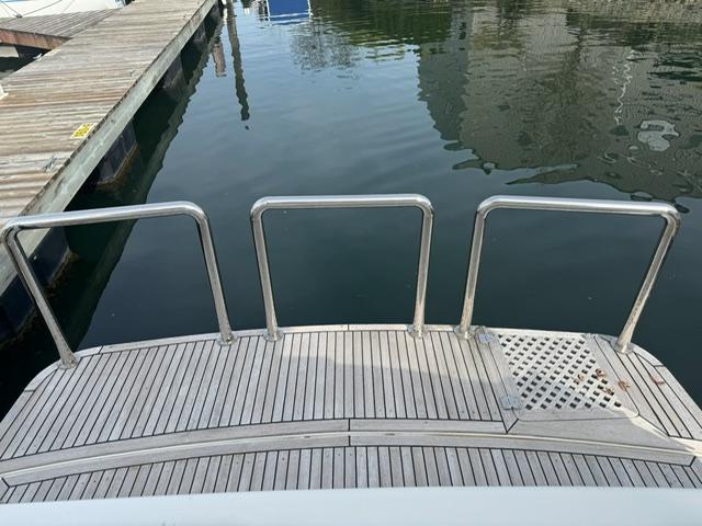 McKinna 57 Pilothouse 2000 yacht stern with wooden deck and metal railings.