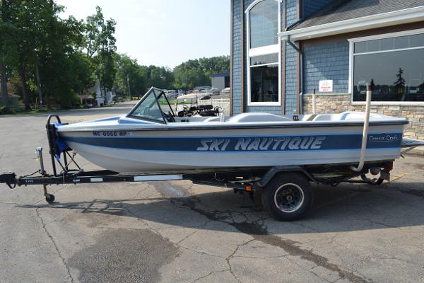 1989 Correct Craft Ski Nautique boat on trailer, parked outside a building.