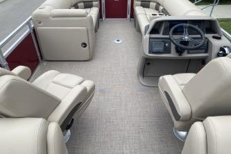 2024 Sun Tracker Party Barge 22 DLX interior with beige seating and steering console.