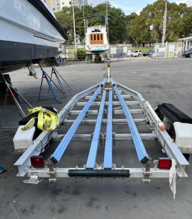 Boat trailer for 2021 Corsair 880 Sport, parked outdoors on concrete surface.