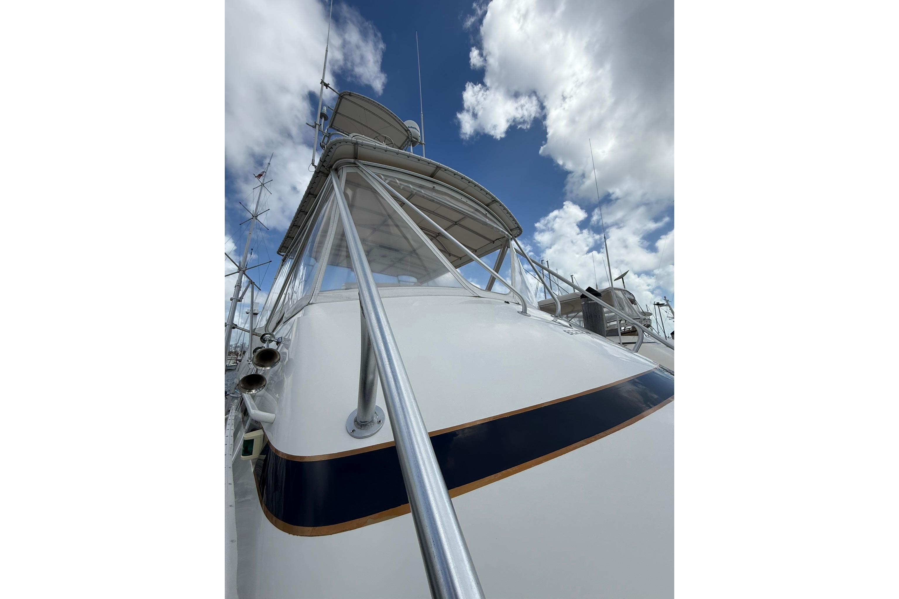 1988 Bertram 43 Flybridge yacht with clear sky and clouds.