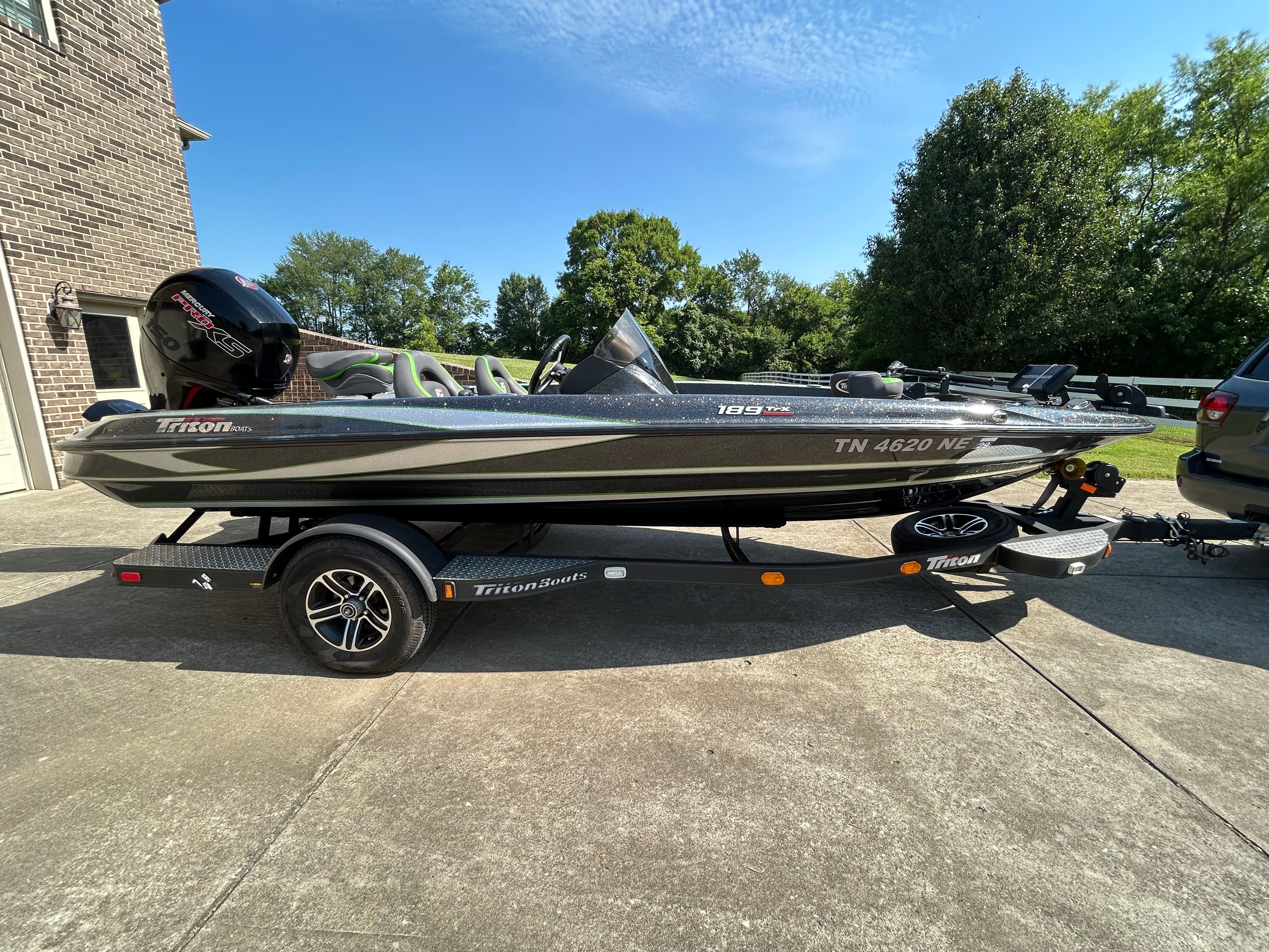 A gray 2020 Trident 189 TRX boat on a trailer in a driveway.