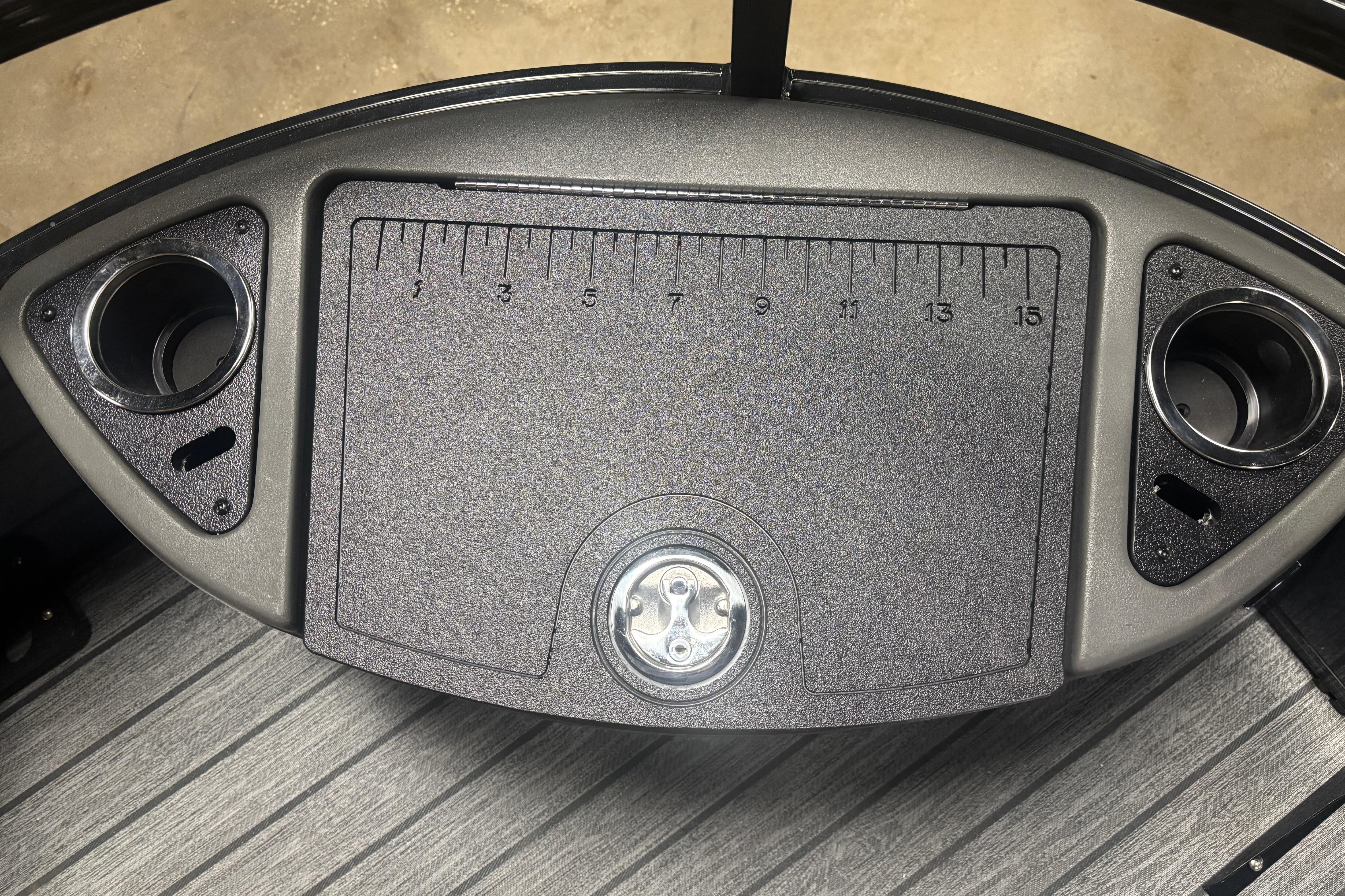 2026 Ranger 223F boat console with ruler and cup holders on textured surface.