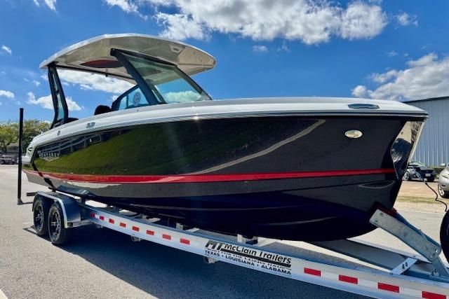 2026 Monterey Elite 25 OB boat on trailer under blue sky.