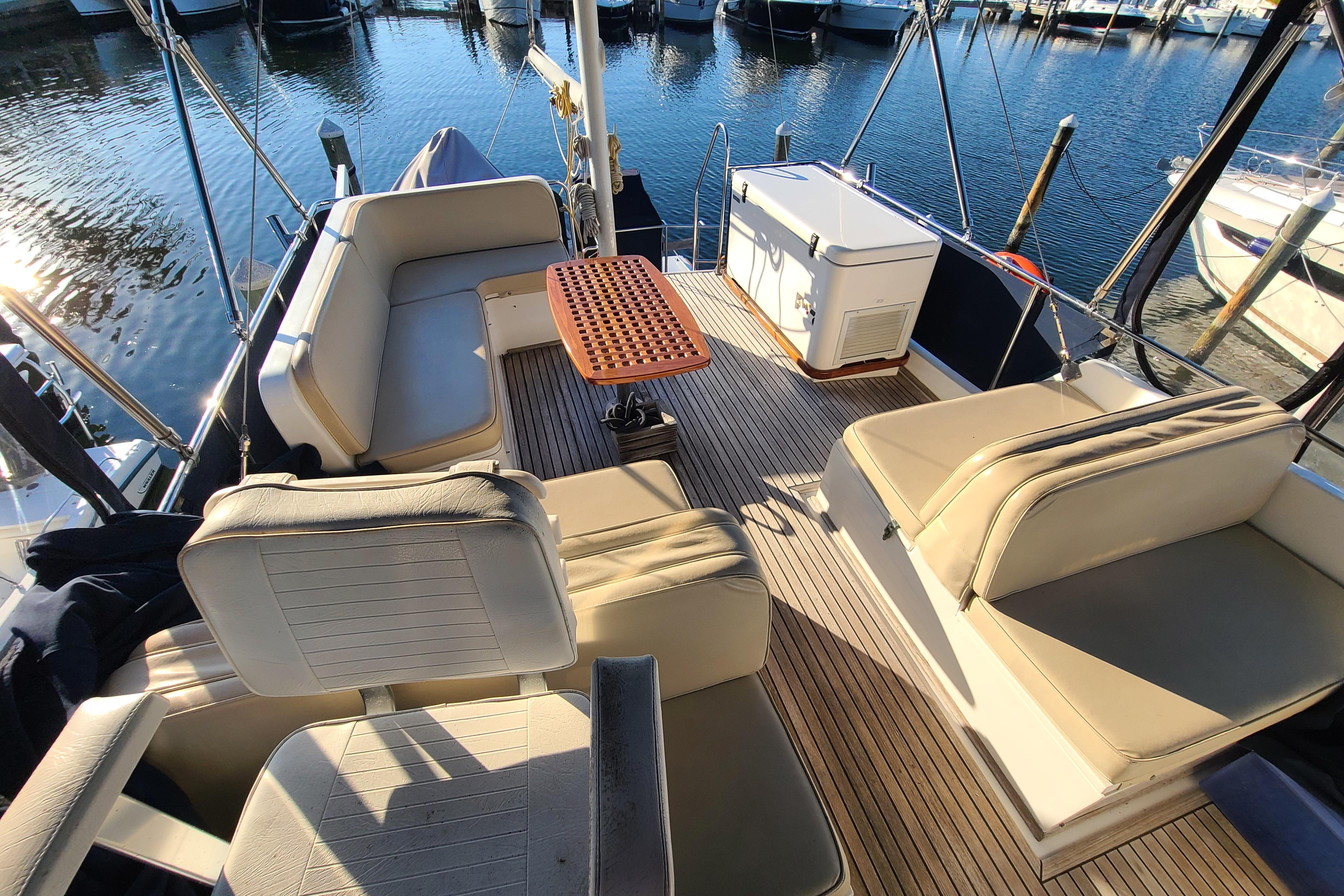 Grand Banks 46 Classic 2000 yacht deck with seating and table, docked at marina.