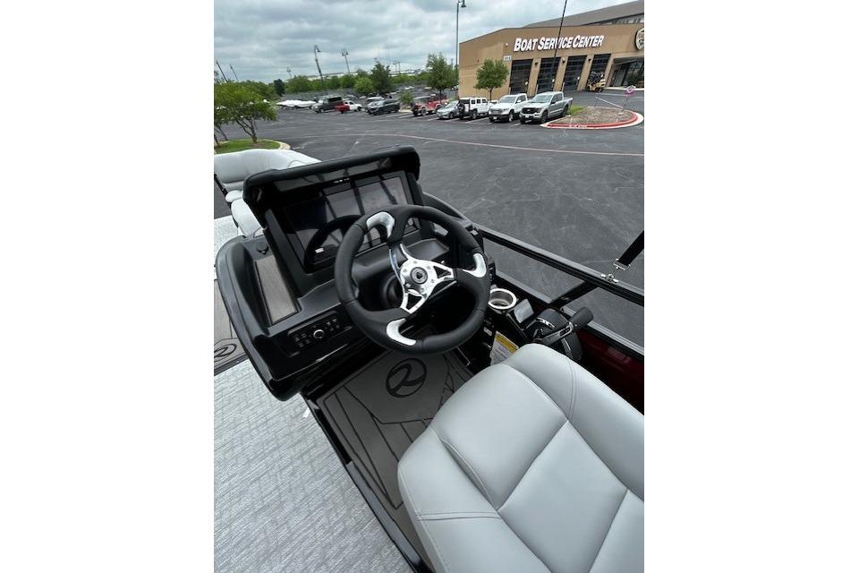 2026 Regency 250 DL boat interior with steering wheel and seating at a boat service center.