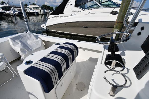2021 Eastern 248 Center Console boat interior with striped seating and docked yachts.