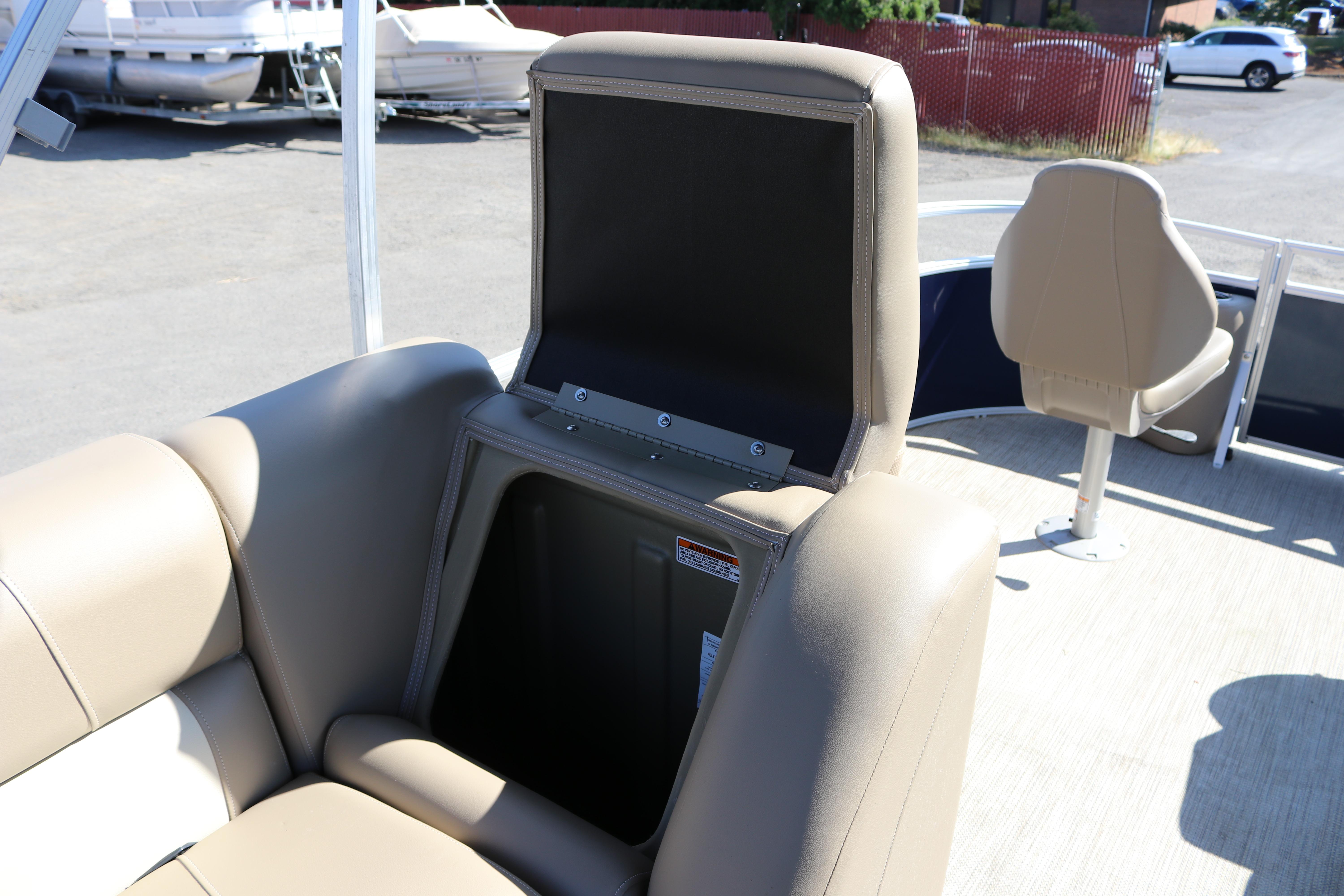 2025 Sun Chaser Vista Fish 18 boat with open storage compartment and beige seating.
